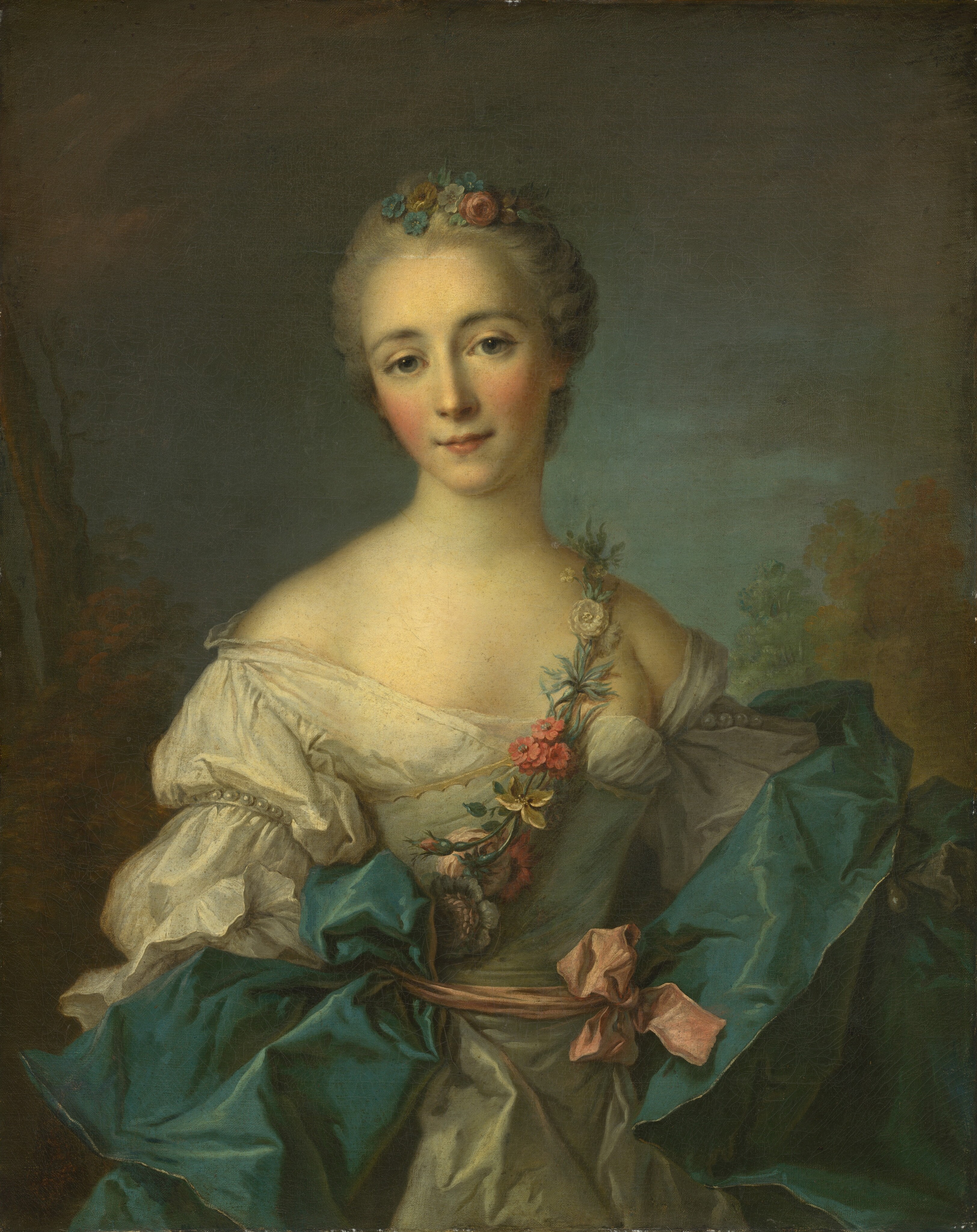 This painting is a portrait of a woman from the waist up. She has delicate facial features, with pale skin, rosy cheeks, large blue eyes, fine eyebrows, and a small smile. She is facing us.  Her hair appears light gray and is styled up, with small blue and pink flowers on the top of her head. She wears an off-the-shoulder white gown, with a floral garland across her chest that is comprised of small pink, blue, and yellow flowers. She also has teal fabric draped around her and a pink ribbon tied around her waist. The background is mostly dark gray with hints of brown trees below cloudy skies.