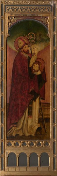 The image shows the upper half of a standing figure. The person has a full beard and mustache, a calm expression, and wears a bishop's mitre adorned with gold and red decoration. They wear a richly patterned red vestment with gold trim and hold a crozier in their hands, making a blessing gesture with their right hand. They support a second head with their left hand. The figure's hair is short and brown, slightly wavy. The background is a subdued green transitioning into a golden halo effect around the figure's head, with an ornate golden frame surrounding the painting.