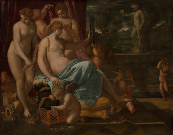 In the left half of this horizontal painting, a bare-chested, seated woman, Venus, is tended by three nude women and several child-like, nude, winged putti. All the women and putti have pale, peachy skin. To our right, a statue of a man stands on an ornately carved pedestal on a veranda in front of a distant landscape. Venus sits facing our right and she looks into a rectangular, black-framed mirror she holds up with her left hand. Her blond hair is braided and she has delicate features. A sky-blue cloth wraps around her waist and lap, and covers her legs. One foot rests on the lap of a seated putto, who ties on a sandal. Another putto helps hold up the mirror. A third putto near us, in front of Venus, pulls strings of pearls from a gold box and the fourth, in the lower left corner, lifts a comb and long needle out of a gilded, rectangular box. Two of the women behind Venus tend to her hair and the third holds up and gazes at a teardrop-shaped pearl. A dusky rose-pink curtain falls behind the women and putti. The view opens onto a terrace on the right half of the painting. A gray stone sculpture of a nude man holding up a bunch of grapes with one hand and bracing a tall stick with the other stands facing our left on an ornately carved base. The base is made up of a wide, shallow bowl above a single pedestal foot. In the distance, two people sit against a tall balustrade. The person on the left wears gold-colored armor, a helmet, and holds a long spear. The bearded man to the right appears to be nude as he leans to the side toward his companion, resting his hand and chin along a staff propped on the bench's seat. Trees and mountains in the landscape beyond are painted with brown, deep gray, and forest and sage green. A sliver of white sky along the horizon brightens an otherwise steel-gray sky.