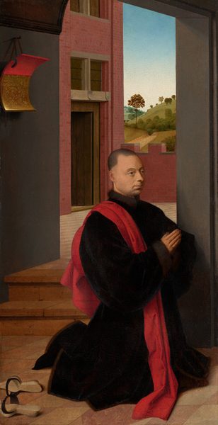 A pale-skinned man with close-cropped, dark hair kneels near two steps leading from our interior space to a distant landscape in this vertical painting. He faces our right, almost in profile, and his dark hairline sits high on his forehead. He looks off to our right with hazel eyes over a long nose and a pale mouth. His voluminous black robe is trimmed with brown fur, and a red scarf drapes over his near shoulder. Two wooden clogs with black straps lie nearby, to our left. The floor under him is checkered in tan and ginger brown. Just beyond him are two brick-red steps flanked by a gray doorway to our right and a wall to our left. A rectangular shield, curved like a piece of paper curling forward, hangs from a strap on the wall to our left. The top half of the shield is scarlet red, and the bottom has gold, leafy designs against a caramel-brown background. The steps lead to an open courtyard. A three-story, brick building rises on the left side with an open wooden door at the ground level and two rows of windows above. Beyond a section of a crenellated brick wall is a hilly landscape studded with trees. The sky above fades from pale blue along the top edge of the painting to nearly white along the horizon.