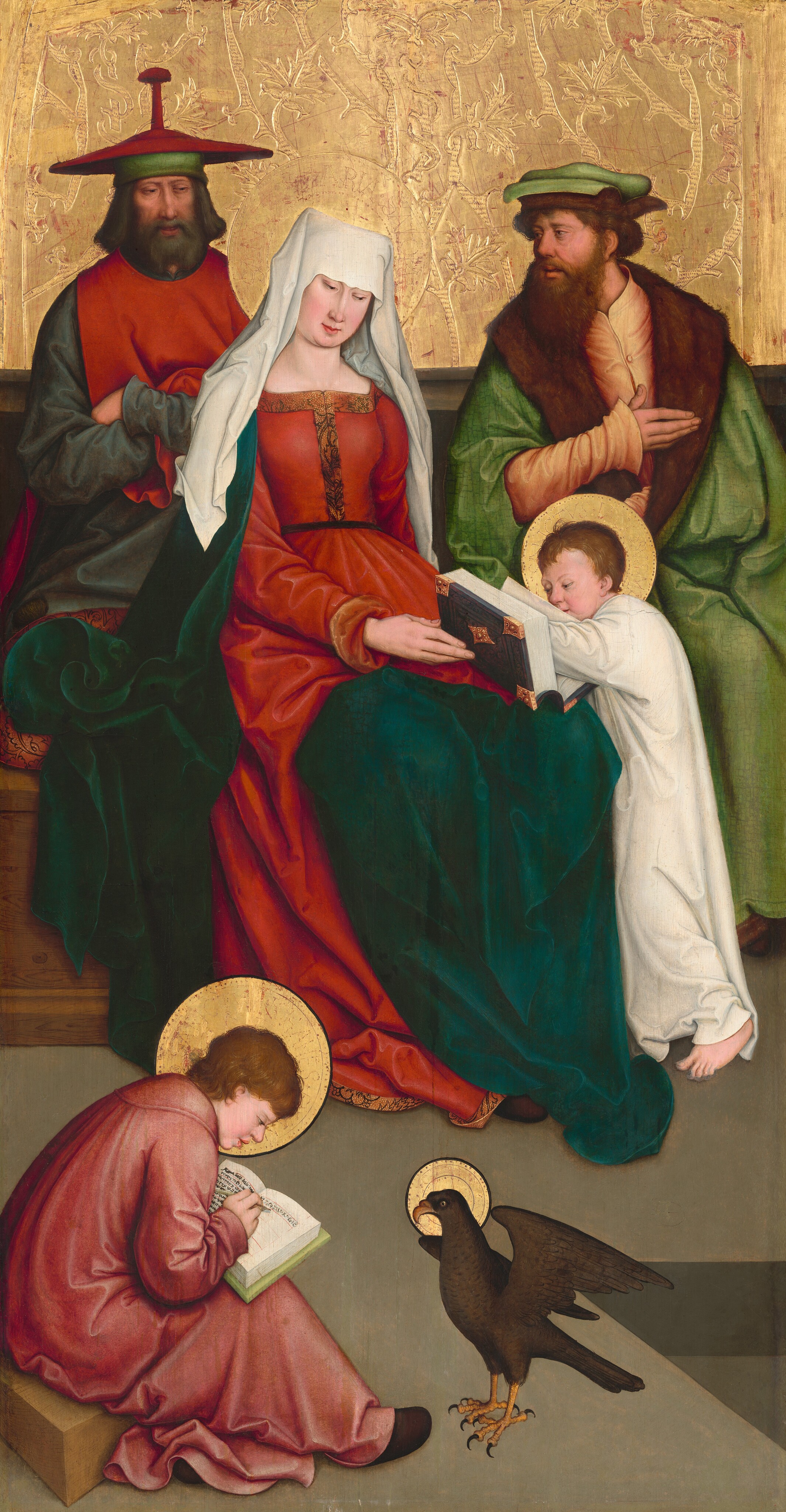 This painting features five people sitting or kneeling alongside a brown bird. In the center, a woman in a red gown holds an open book, looking downward. She wears a white head-covering and a dark green shawl. To her left, a man with a dark beard wears a red tunic and wide-brimmed red hat, while to her right, another bearded man in a bright green fur-lined cloak looks towards the woman, one hand flat on his chest. A child in white stands to the right of the woman in front of the man in the green cloak, his hand in the open book the woman holds, looking down into the pages. The woman and the two men appear to sit on a brown wooden bench. In the bottom left corner, on the green floor, another person sits on a small wooden block, holding another open book. This person has short brown hair and a pink robe. To the right of this person is a large brown bird, its wings raised upward. The bird, seated person, young child, and woman all have golden halos. All of the people have pale skin. The wall behind those on the bench is textured gold.