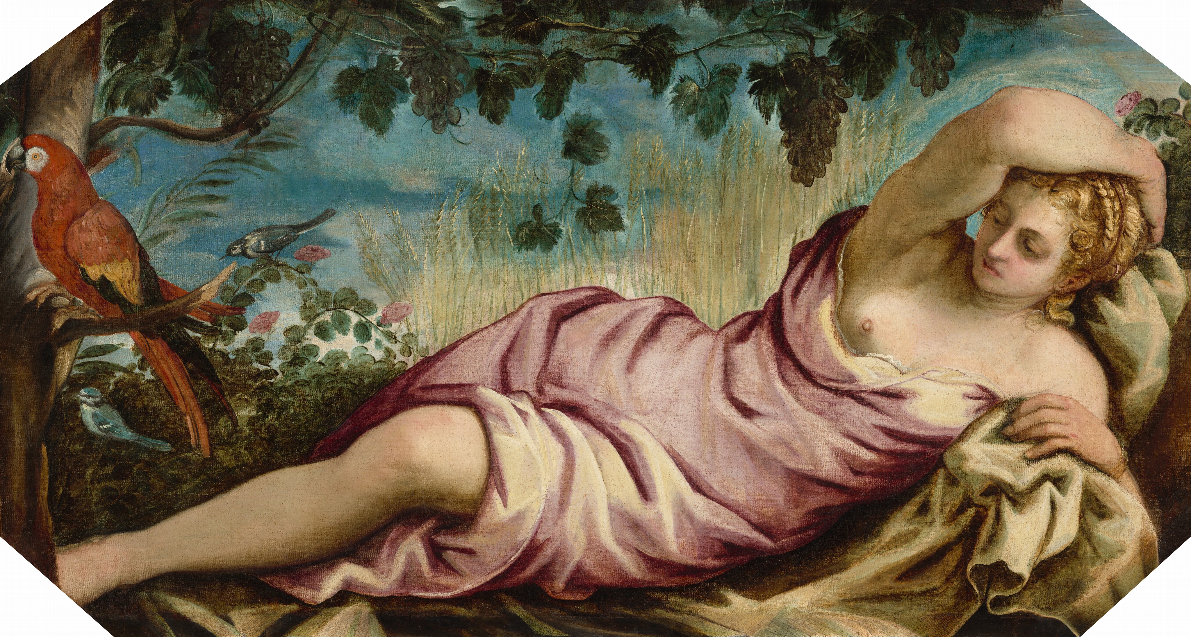 A pale-skinned woman with honey-blond hair reclines among wheat stalks and grape vines in this horizontal painting. She lies on her side with her head to our right and her body facing us. Her upper body is propped on her left elbow. Her other arm is raised and bent at the elbow so her hand cups the back of her head. Her bottom hand rests on a tan-colored cloth spread under her, and her head tilts down as she looks with hooded eyes off to the left. Curls frame her face, and braids cross the top of her head. She has flushed cheeks, smooth skin, and pink lips. A mauve-pink garment wraps around her torso and legs but leaves her shoulders, one breast, and her bottom leg bare from the knee down. That foot disappears behind a section of a dark brown tree trunk that rises up the left side of the composition. A brick-red parrot with gold and black wings and tail sits on a short, broken branch there, facing our left. A slate-blue bird sits on the curving branch of a bush nearby, which has oval-shaped, moss-green leaves and delicate pink blossoms. Dark green grape leaves and clusters dangle over the woman from the top edge of the canvas, and almost span the width of the painting. Beyond the woman is a row of golden wheat stalks against a celestial-blue sky. The corners of the image are white, indicating that the painting had been shaped or framed to create an elongated, octagonal shape.