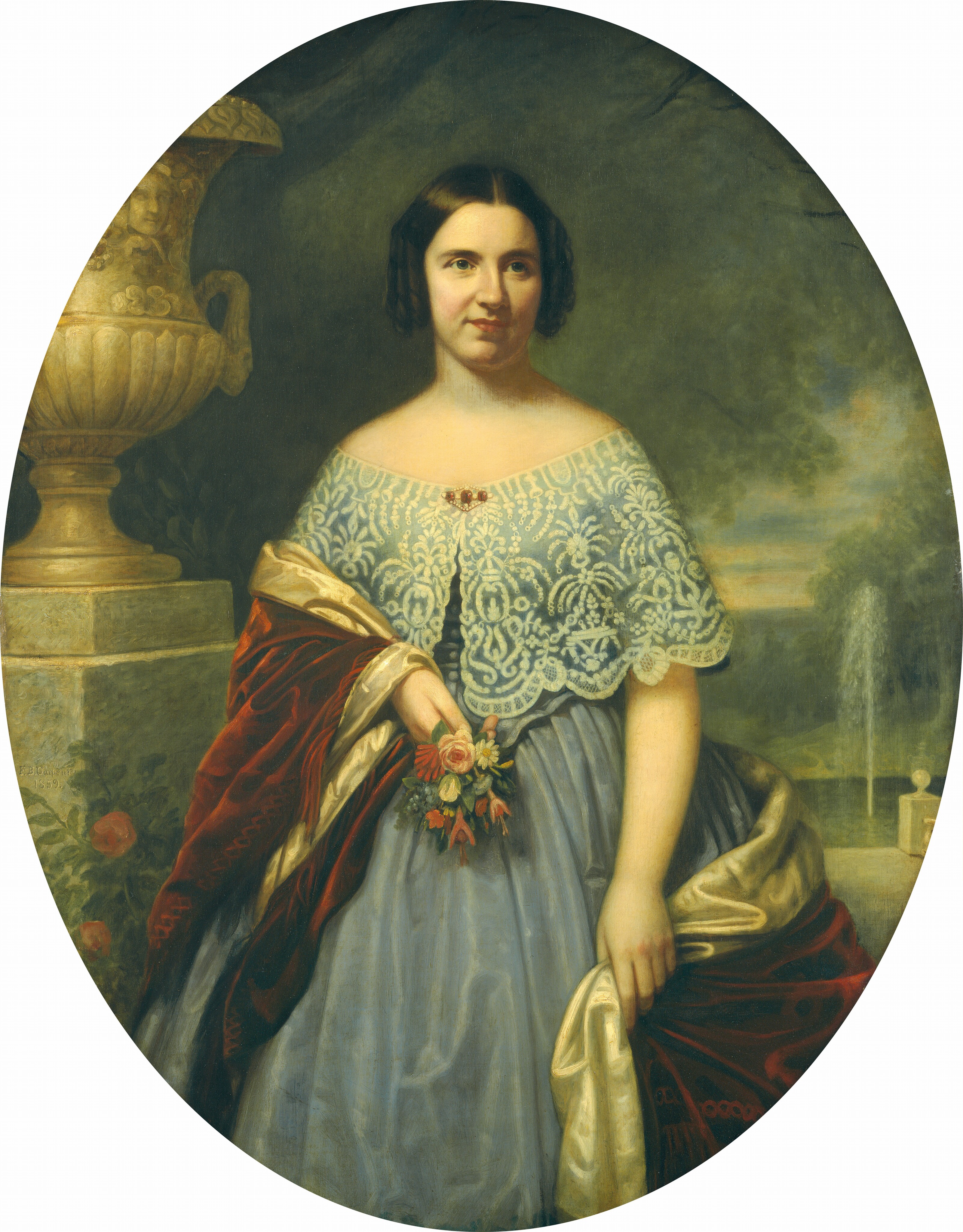 The image shows a woman standing with her face towards the viewer. She has dark, straight hair, fair skin, and is wearing an elegant outfit with a red velvet shawl. She is holding a bouquet of red and orange flowers. The background includes a stone urn, greenery, a fountain, and part of a garden.