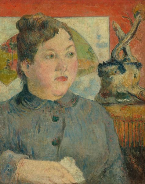 This painting shows a woman from the chest up, with her head slightly turned to the right. She has fair skin, red lips, and brown hair in an updo. She wears a gray-blue dress with black buttons and holds a white object in her right hand, perhaps a handkerchief. The background is red, with a white panel on the left behind her head with a green arch featuring floral pattern, and a decorative object on the right that looks like a wooden stump on a box or shelf.
