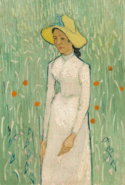 Shown from the knees up, a pale-skinned woman wearing a floppy, canary-yellow hat and a long white dress stands in a field of spring green in this vertical painting. Brushstrokes and loose dabs of paint are visible throughout. The woman’s body is angled to our left, and she looks off in that direction with bright green eyes. Her nose, eyebrows, and narrow chin are outlined with medium brown, and her pink lips are closed. Her black hair is pulled back under the hat, the wide brim of which droops down either side of her face. A sky-blue ribbon or decoration is on the front of the crown. Her dress has a high collar, a fitted bodice, long sleeves, and a long skirt. Pale pink daubs on the white dress are thickly applied so the texture of the paint can be seen on the surface of the canvas. The background is painted with long and short curved dashes of celery green layered over laurel and cool green. Several tangerine-orange dots, a few shell-pink dabs, and some angular, heart-shaped forms in cobalt blue to each side of the woman suggest flowers.