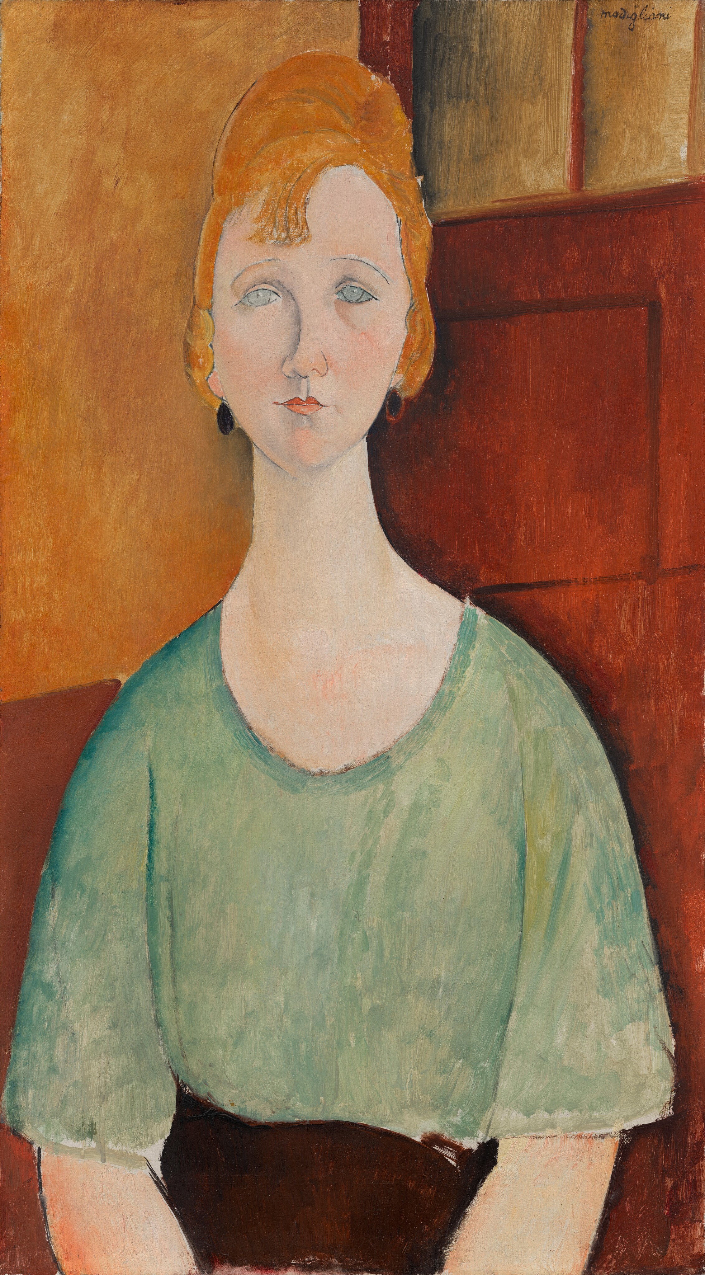 Shown from the lap up, a pale-skinned woman with an oval face and long neck sits facing us in this vertical painting. The portrait is created with areas of mottled colors outlined with black lines. Her body faces us, and she looks out with pale blue eyes, the irises almost white. Her thin eyebrows slope down the sides and her small, dark peach lips are closed. Golden-orange hair is piled atop her head and a few bangs fall onto her high forehead. Black oval earrings hang from her lobes. Her shoulders also slope unnaturally down. Her mint-green shirt has a scooped neckline and elbow-length sleeves, and it appears to be tucked into a brown skirt or pants. The background is honey orange in the top left quadrant, amber brown in the lower left, and a russet brown door with windows across the top fills the right half. The artist signed the top right corner, “modigliani.”