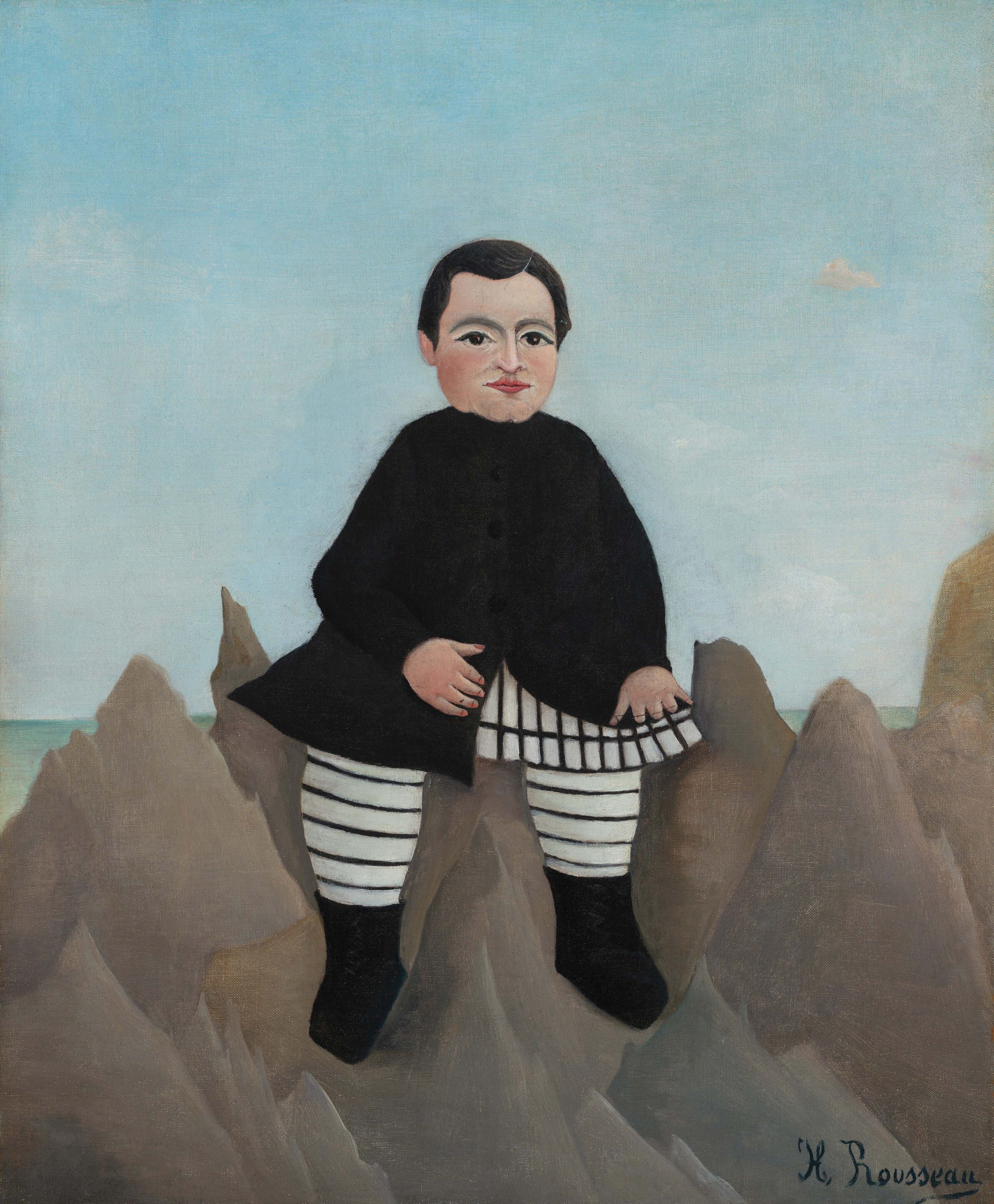 A pale-skinned boy with round, almost doll-like proportions sits on pointed rocks in front of a pale blue sky in this slightly stylized, vertical painting. The boy’s body and face are square to us. His dark hair is neatly parted to our right and combed smooth. He looks out with over-large, close-set, dark eyes under curved brows, a straight, adult-like nose, and wide, full pink lips. He has a round face, smooth, flushed cheeks, and a wide, cleft chin. He wears a black jacket that falls open over a skirt-like white garment painted with a black grid. His stockings are white with thin black stripes, and he wears ankle-high black boots. The craggy rocks on which he perches are painted with tones of peanut and ash brown. A strip of turquoise green beyond the rocks suggests a body of water under the blue sky. The artist signed the painting in the lower right corner, “H. Rousseau.”