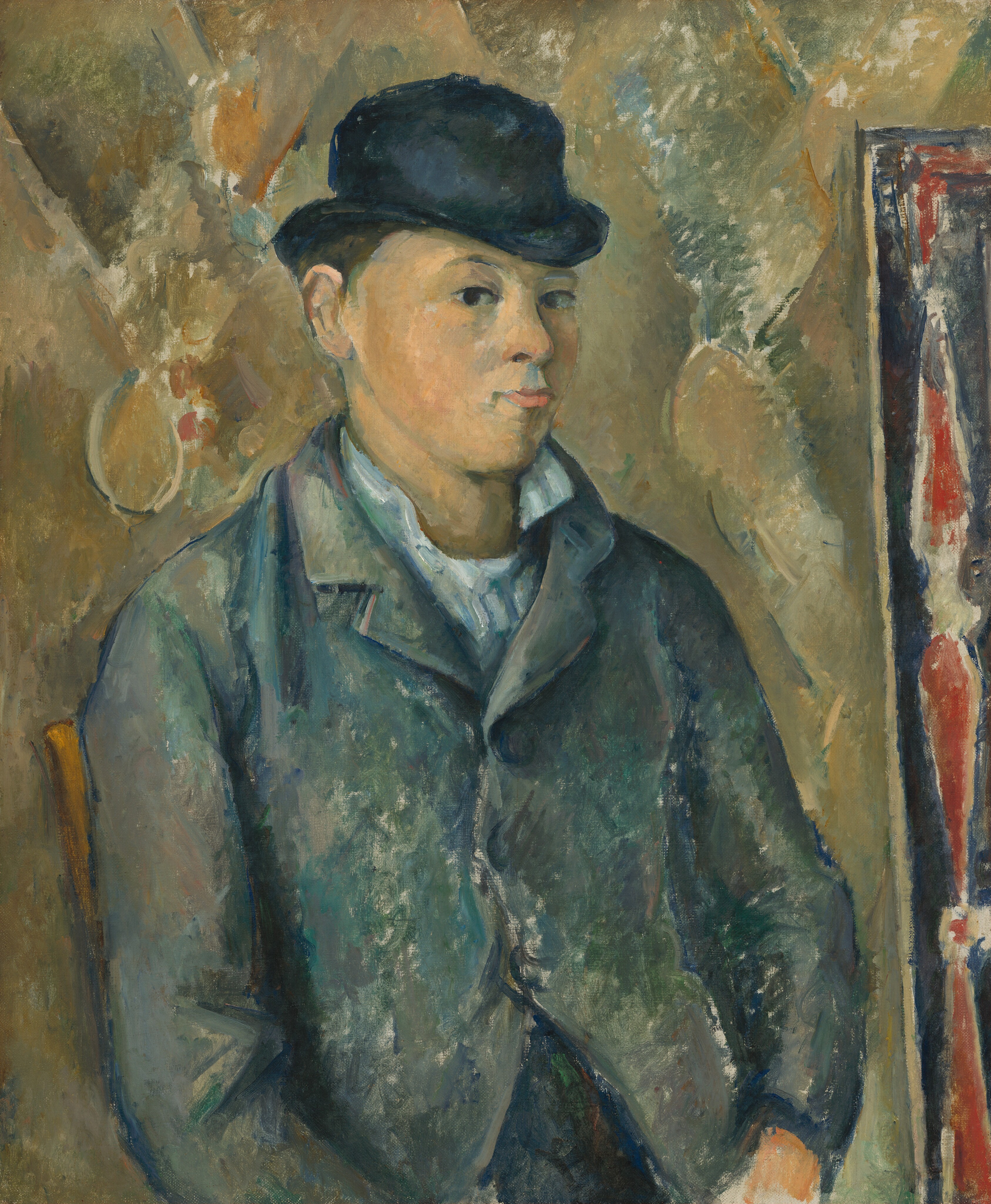 Shown from the waist up, pale-skinned young man wearing a bowler hat looks at us from the corners of his eyes in this vertical portrait painting. His body is angled to our right, and he cuts his dark eyes back to look at us, his lips pursed. He has a wide face, round cheeks, and a narrow chin. His white lapels are flipped up, and he wears a buttoned blue jacket. The black bowler hat seems a little too small for his head. The man and setting are painted with areas of mottled, streaked color. For instance, his peachy face is shaded with visible strokes of slate blue. His white collar is a blend of ice blue and frosty green, and his jacket is built up with daubs and strokes of marine blue, moss green, and gray. The white of the canvas underneath shows through in some areas, especially in the jacket. The wrist of one hand resting in the man’s lap is visible, and the back rail of the wooden chair in which he sits peeks out past the shoulder to our left. The wall behind him is painted loosely with the suggestion of a diamond pattern in laurel and olive green, parchment brown, rust orange, and muted blue. A rail or frame running close and parallel to the right edge of the canvas is patterned with elongated red teardrop shapes outlined by white, against a celestial-blue background.