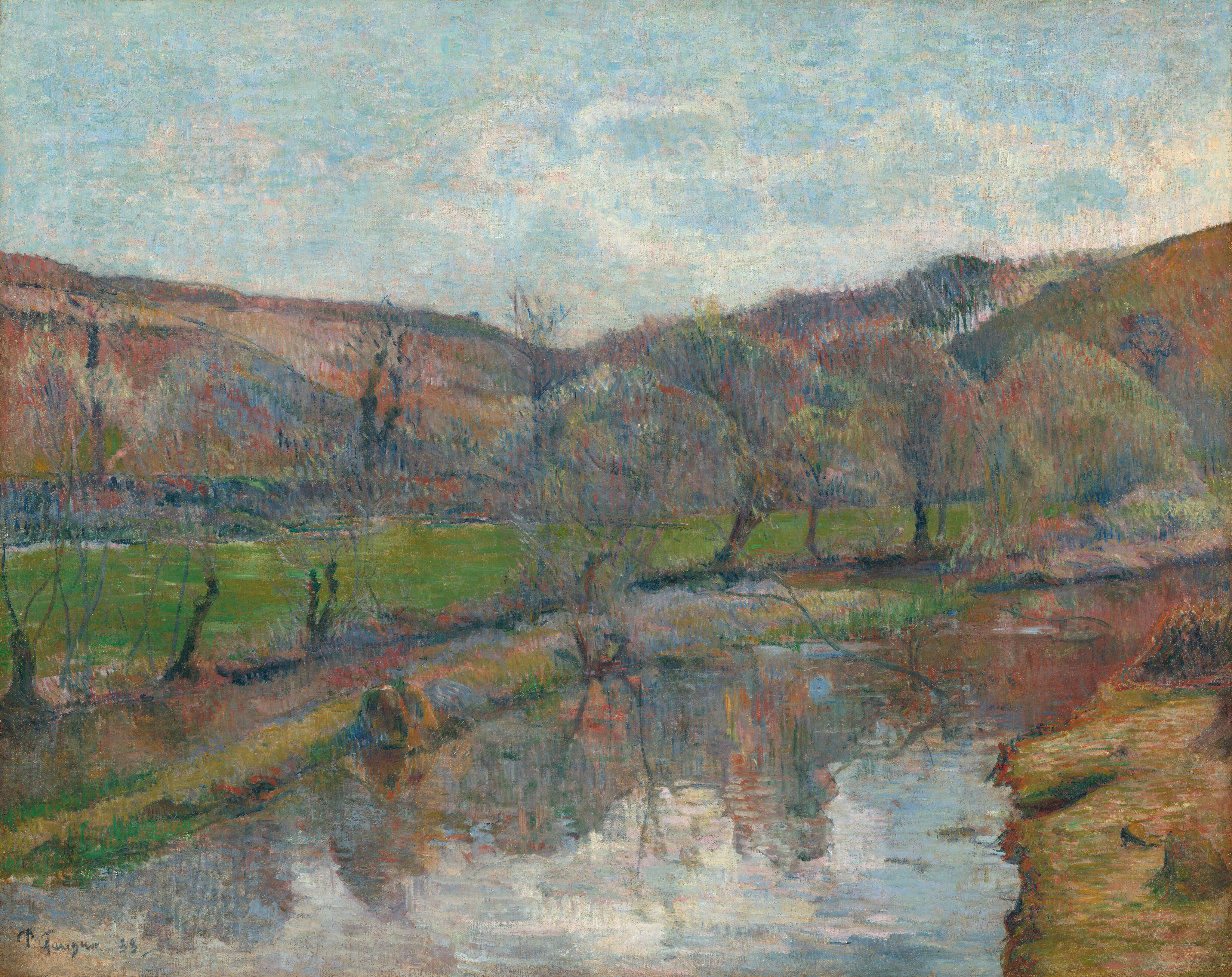A waterway flanked by low banks curves away from us in front of a band of rolling hills in this loosely painted horizontal landscape. The water is created with wide strokes of white, ice blue, or the muted jewel tones of the hills. The riverbank in the lower right corner is also painted with wide strokes but in peanut brown, soft green, and petal pink. Tree trunks along the far bank have ghostly canopies that blend into the hills, which are painted with vertical strokes of celestial blue, amber brown, pale green, and rose pink. In the top third of the composition, a few white clouds trundle across the vivid blue sky. The artist signed and dated the painting in the lower left corner, “P. Gauguin 88.”