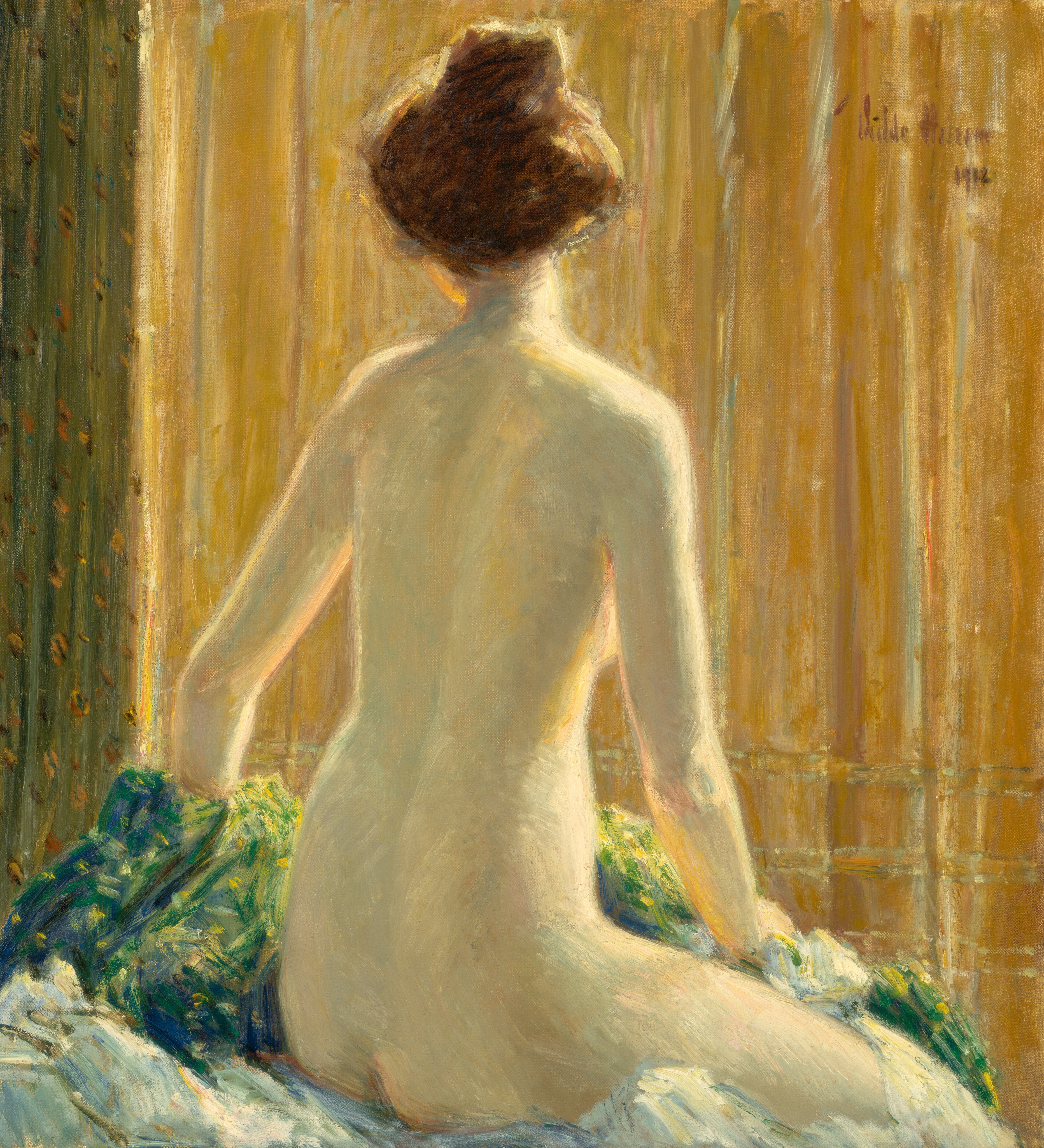 A nude, pale-skinned woman sits facing away from us on a surface with bunches of blue and green-toned fabrics in this vertical painting. The woman’s right knee and torso angle away from us to the right, but she turns her head a bit to our left so we see the underside of her chin. Her brown hair is pulled up loosely into a high bun. Her right hand rests on fabric bunched on that leg, and her other hand disappears on the far side of lemon-lime green and celestial-blue pile of cloth near the lower left corner of the painting. The background is mostly golden yellow, perhaps a curtain, with some vertical pleats in moss green along the left side. The woman is lit from our right so the edges of her right arm, breast, torso, leg, and neck glow. The scene is loosely painted but has an overall soft, blended look. The artist signed and dated the painting in the top right corner, “Childe Hassam 1912.”
