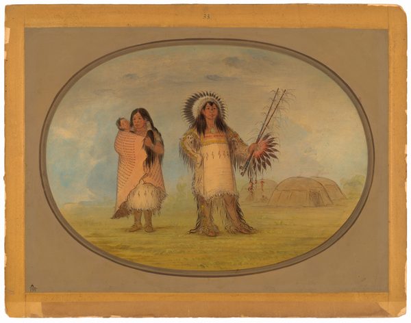 The image shows two adults and an infant. The adult on the right is standing in a frontal pose, wearing an elaborate feathered headdress. Their hair is long, straight, and dark, cascading down their shoulders. They are dressed in a decorative outfit with fringes extending to the ground, and are holding a long implement adorned with feathers in their left hand. The adult on the left is standing and appears to be facing slightly to the right, with their hair also long, straight, and dark. They are wrapped in a patterned blanket and holding a small infant in their arms. The infant is mostly wrapped and has a visible, small face with features that are not detailed. The background features a grassy area with a domed structure with an entrance, suggesting a plains setting, and the sky is slightly cloudy. The entire scene is encased in a softly shaded oval frame within a rectangular border.