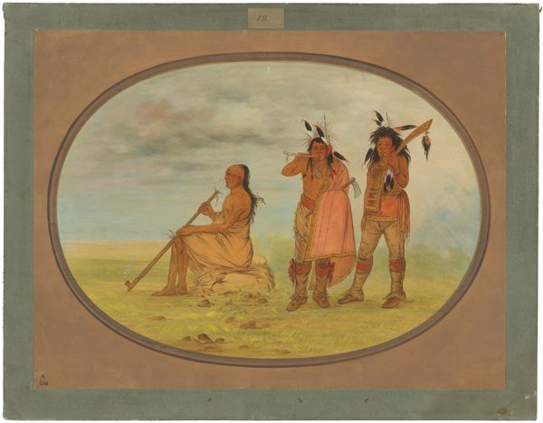 The image shows three individuals against a natural background. On the left, a man is seated on the ground, his body wrapped in a beige cloth. He has long, dark hair and a solemn expression, holding a long pipe. On the right, two standing men are shown from head to toe. Both have dark hair; one with two long braids and the other with a feathered headdress. The man with the headdress holds a shield adorned with feathers. The men wear red leggings, beadwork, fringed garments, necklaces, and jewelry. One has a draped pinkish-white cloth over his shoulder. The background features a grassland with a distant sky overhead.
