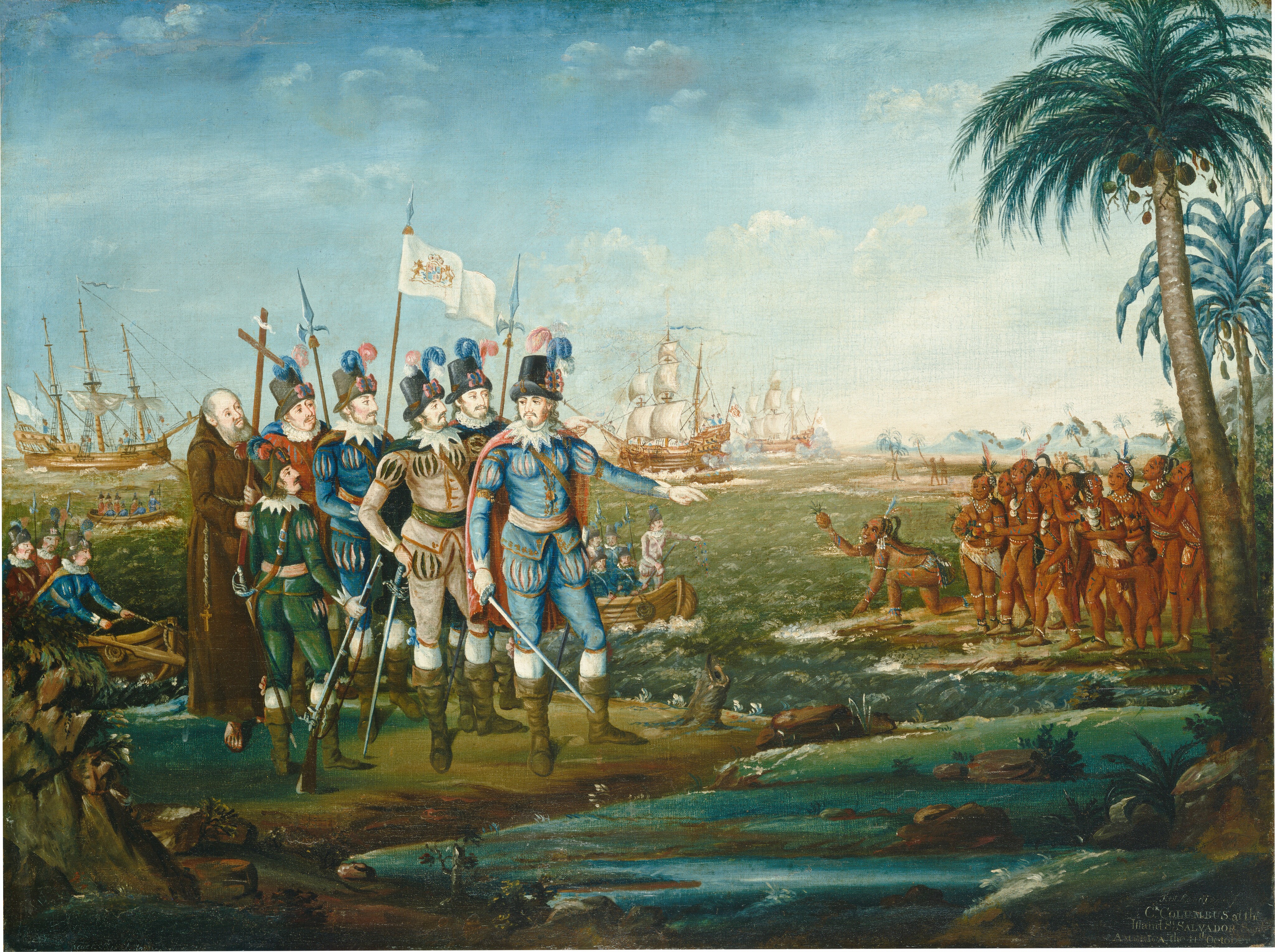 Seven light-skinned men stand closely together at the edge of a body of water across from a group of about a dozen indigenous people with brown skin gathered in the near distance in this horizontal painting. To our left, five of the white men wear tall black hats with blue and pink feathers. In shades of royal blue, parchment white, pine green, or brick red, their caped suits have slashes across the chest, shoulders, and upper thighs. Some hold or wear swords, and most have knee-high, olive-green boots. At the back of the group, a hatless, balding man wears a long brown robe with a rosary and cross hanging from his waist. He holds a tall wooden cross, and the others carry spear-like halberds, a rifle, or a white banner. The man at the front of the group holds a sword down by one side and gestures toward the group of brown-skinned people with his other hand. Two rowboats filled with similarly dressed men approach their position on the left side. Three wooden ships lie in the water beyond the men. The indigenous men, women, and children wear off-white or red loincloths, along with earrings, necklaces, armbands, and anklets. Many have feathers in their dark hair. One person at the front of that group kneels and points toward the water with one hand as he holds out a pineapple with the other. The two groups are separated by a jewel-blue waterway that runs between them. More beach and hazy blue mountains in the deep distance curve toward the center of the composition. The artist signed and dated the painting in the lower left, though the inscription is now incomplete. It reads, “eyer Pin t th January 180.” In the lower right, and inscription reads, “First Landing of C.R COLUMBUS at the Island St SALVADOR South AMERICA the 11th October.”