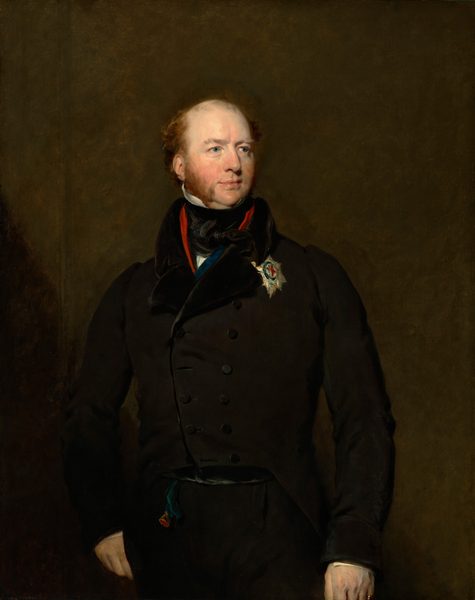 The image displays a man in a portrait from the waist up, in a three-quarter view. He is facing slightly to the right and looking into the distance with a calm expression. The man has fair skin, light reddish-brown hair, sideburns, a defined nose, and a slightly upturned chin. He is wearing a black double-breasted coat with a high collar, a dark waistcoat, a white shirt, and a medal on his chest with an insignia and ribbon. The background is plain and deep brown.
