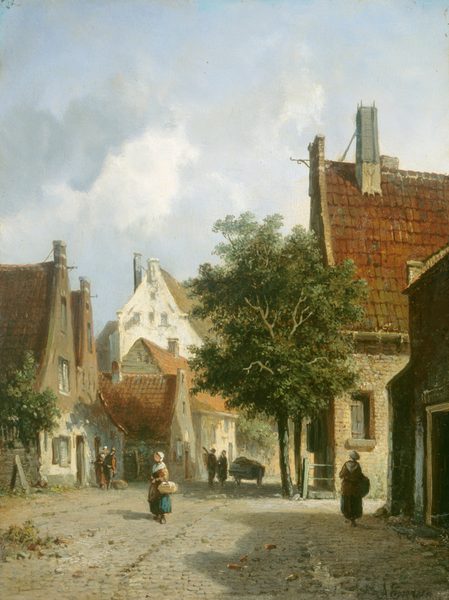 This painting shows a cobblestone street lined on both sides by buildings and tall green trees. A building with a red-tiled roof and stone walls is visible on the right, partly covered by tree branches. On the left are more buildings with red roofs and white walls, some shorter and some taller. People walk along the stone street. Closest to us, two women are visible carrying baskets, both wearing long dresses or skirts in shades of red and blue with white bonnets covering their hair. In the background, farther down the road, two men stand next to a cart, and two people on the left stand near the entrance to one of the buildings. The sky above is cool blue with a few clouds, and the scene is lit with a warm light. The buildings and trees on the right side of the street cast dark shadows.