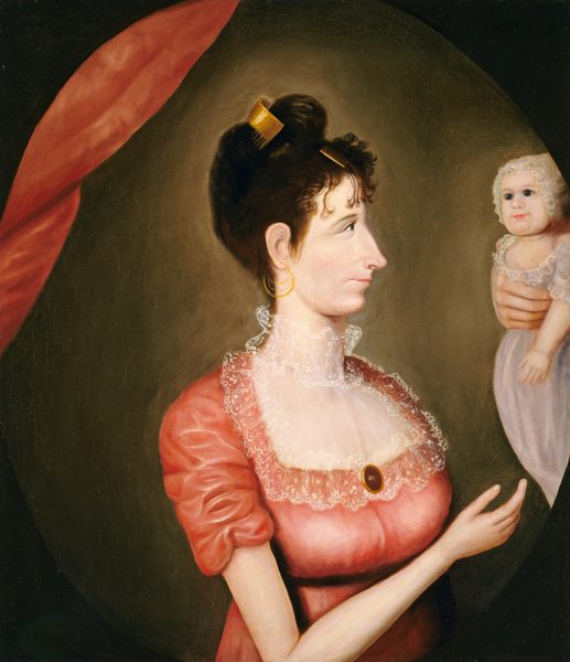 This painting shows the upper body of a woman in a side profile view, facing the right, where a baby is held up. The woman has a long, pointed nose and thin lips, with her black hair styled up and decorated with a gold comb. She wears a red dress with puffy sleeves, a lace collar, and a gold pendant. She also wears gold hoop earrings. She is reaching one hand up towards the baby. The baby, held by the hand of an unseen person, wears a pale gray dress with lace details and a lacy cap over its head. The woman, baby, and hand all have pale skin. The background is brown with lighter areas around the woman and baby, and a section of red draping near the top left. The painting is an oval, and beyond that is a black rectangular border.