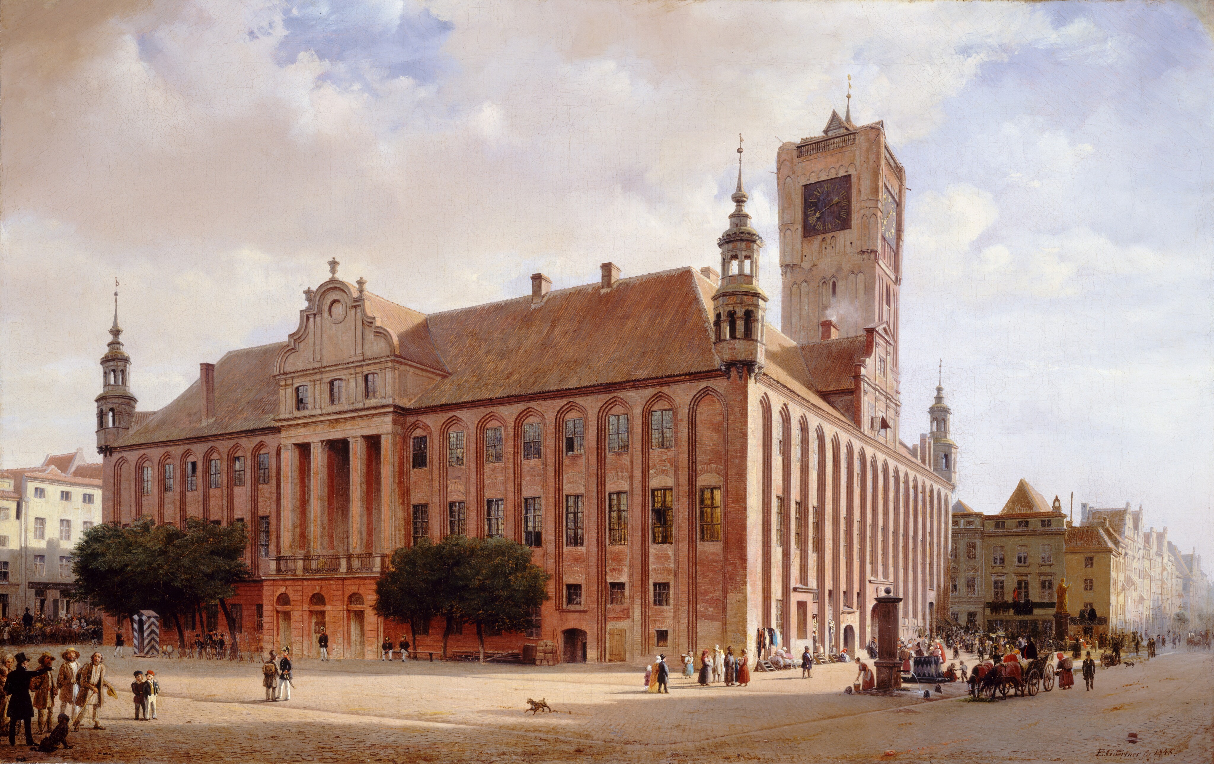 This painting shows a large pink brick building with grand architecture. Above it, the sky is a blend of white and light blue hues with fluffy clouds. The architectural details are intricate, such as tall windows and arched doorways. Behind the building, on the right, there appears to be a large clock tower, and other small buildings line the street in the distance to the left and right. Crowds of small people can be seen around the building. Some are dressed as soldiers, while others wear a mix of formal and plain clothing. On the far left and right, we can see horse-drawn carriages on the roads.