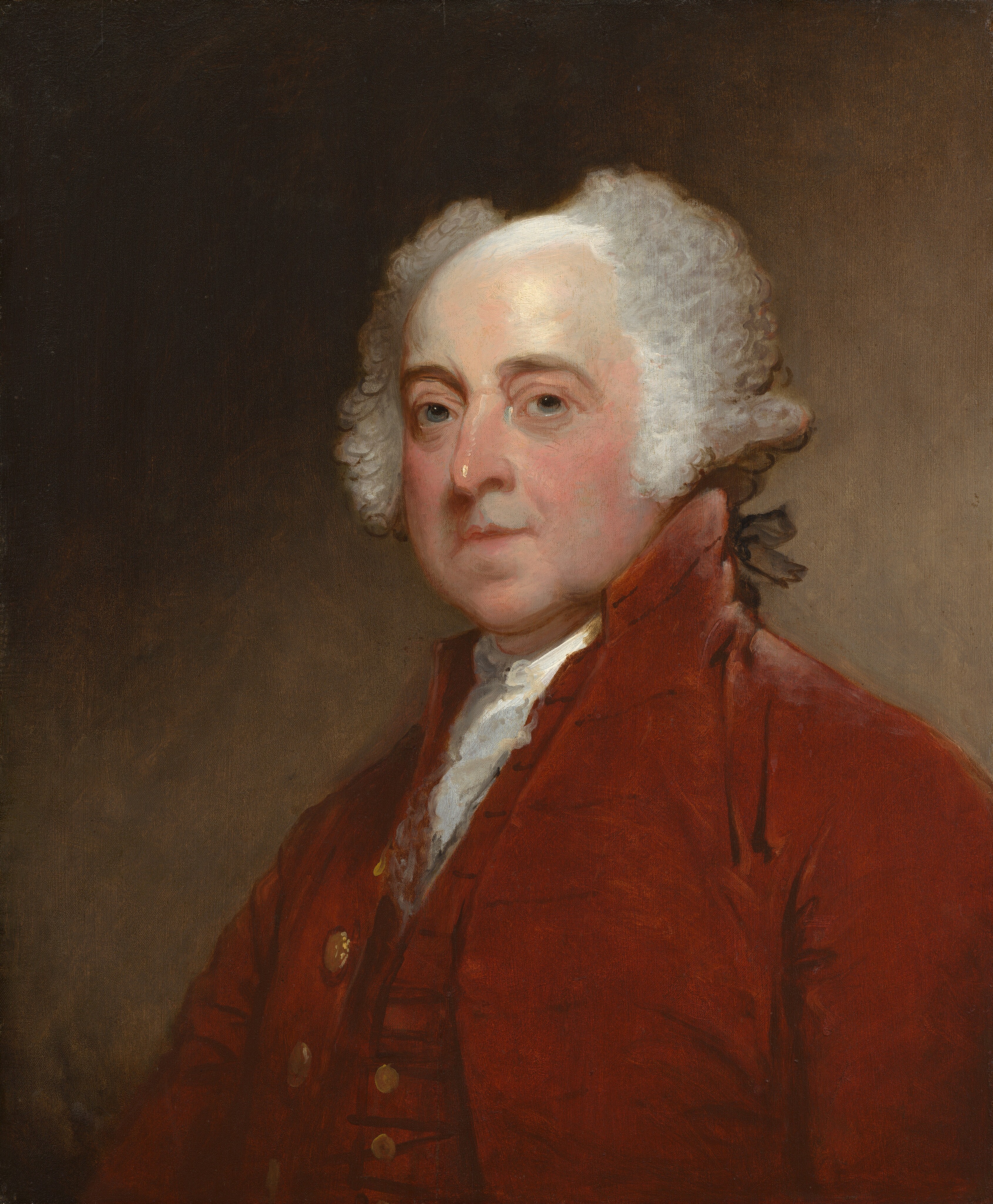 Shown from the chest up, a balding, light-skinned man wears a port-red vest and coat in this vertical portrait painting. The man’s shoulders are angled to our right, but he turns his head to look at us from the corners of gray eyes under heavy, brown brows. His under-eyes are shaded blue and lined with wrinkles. He has a bumped nose, bow-shaped lips, a round chin, fleshy, flushed cheeks, and sagging jowls. His white hair sweeps up and to either side of a bald patch, painted with a white sheen, on the top of his head. Curls come down over each ear and longer hair in the back is tied with a black ribbon. He wears a white ruffled cravat under the deep red vest and coat, both of which have gold-colored buttons down the front. The background lightens from earth brown in the upper left corner to paler, peanut brown in the lower right.