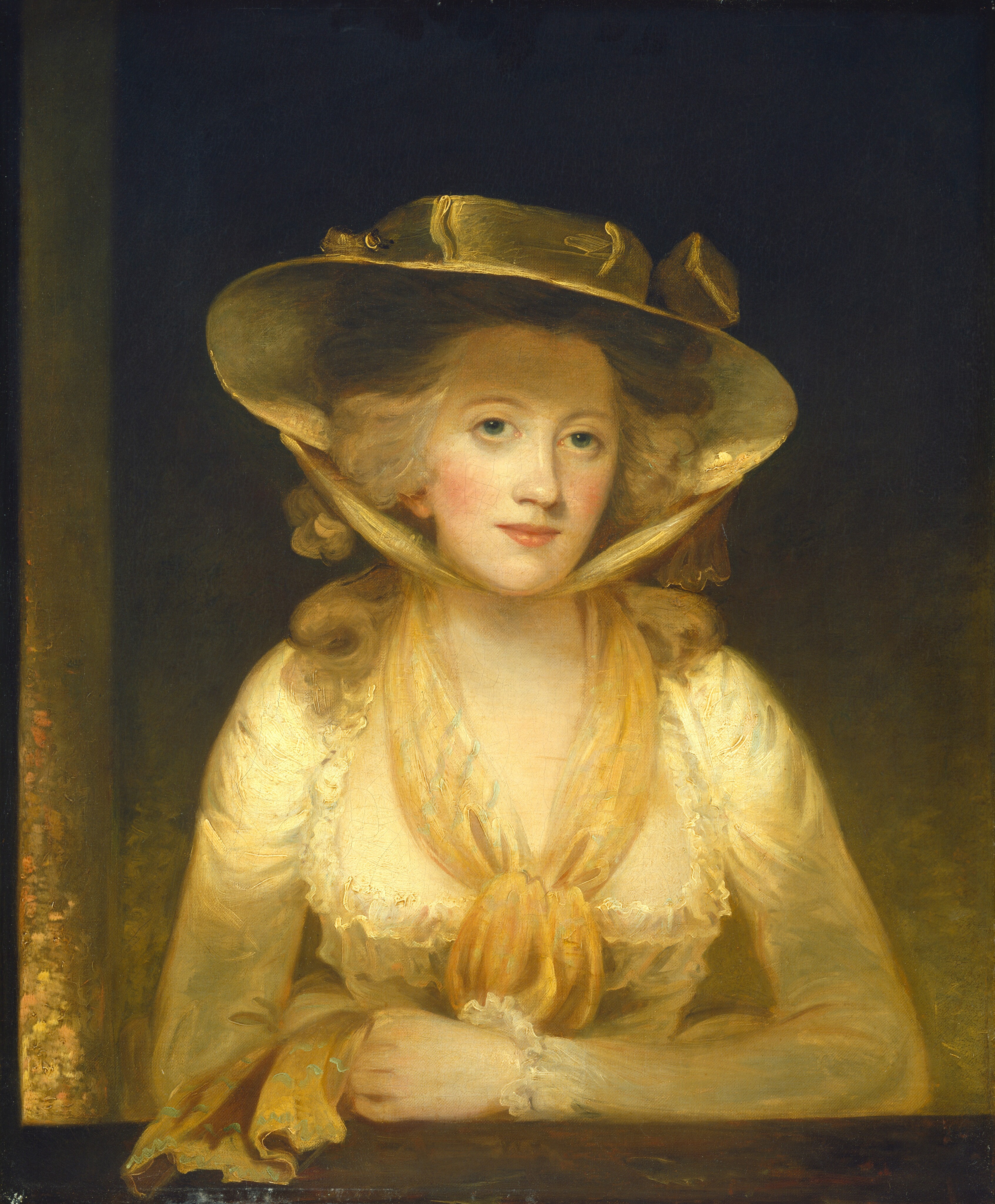 This painting shows a woman from the waist up, her forearms resting on a brown surface in front of her. She has fair skin, rosy cheeks, light blue eyes, and blonde hair styled in loose curls. She wears a yellow wide-brimmed hat with a bow tied under her chin, a yellow scarf, and a pale-yellow lacy dress with long sleeves and wide neckline. The background is a blend of yellow and black.