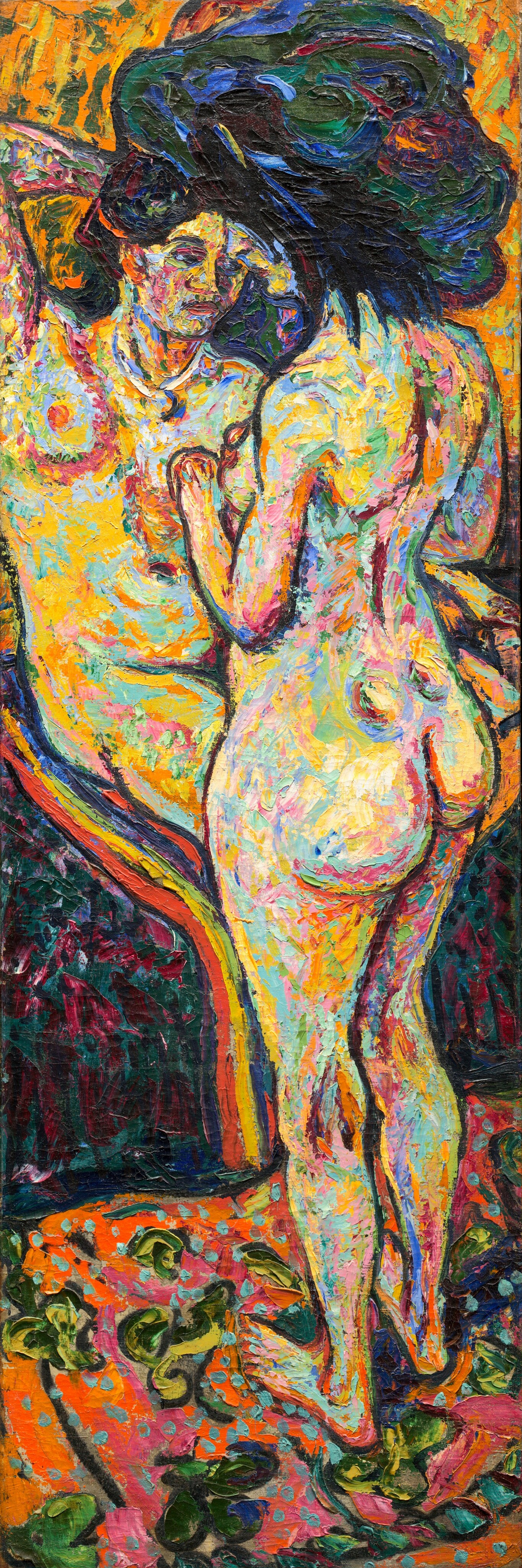 This tall, vertical painting shows two nude women next to each other, one standing and one sitting. The women both have light skin painted in shades of cream and pale yellow, with highlights of seafoam green, dark blue, and magenta. The seated woman faces us, turned slightly to the right, while the standing woman has her back to us, facing the left and partially blocking the seated woman. Both women appear to have dark hair, although their hair and the edges of their faces blur together against a patch of dark green in the background. Outside of this green patch, the wall behind them is a vibrant orange with streaks of dark and light green. The floor beneath the women is a bright coral color with swirling patterns in yellow and green, like a patterned rug. Below the chair under the seated woman is a patch of dark red with dark green lines. The brushstrokes in the painting are thick and bold, layering bright colors over one another.