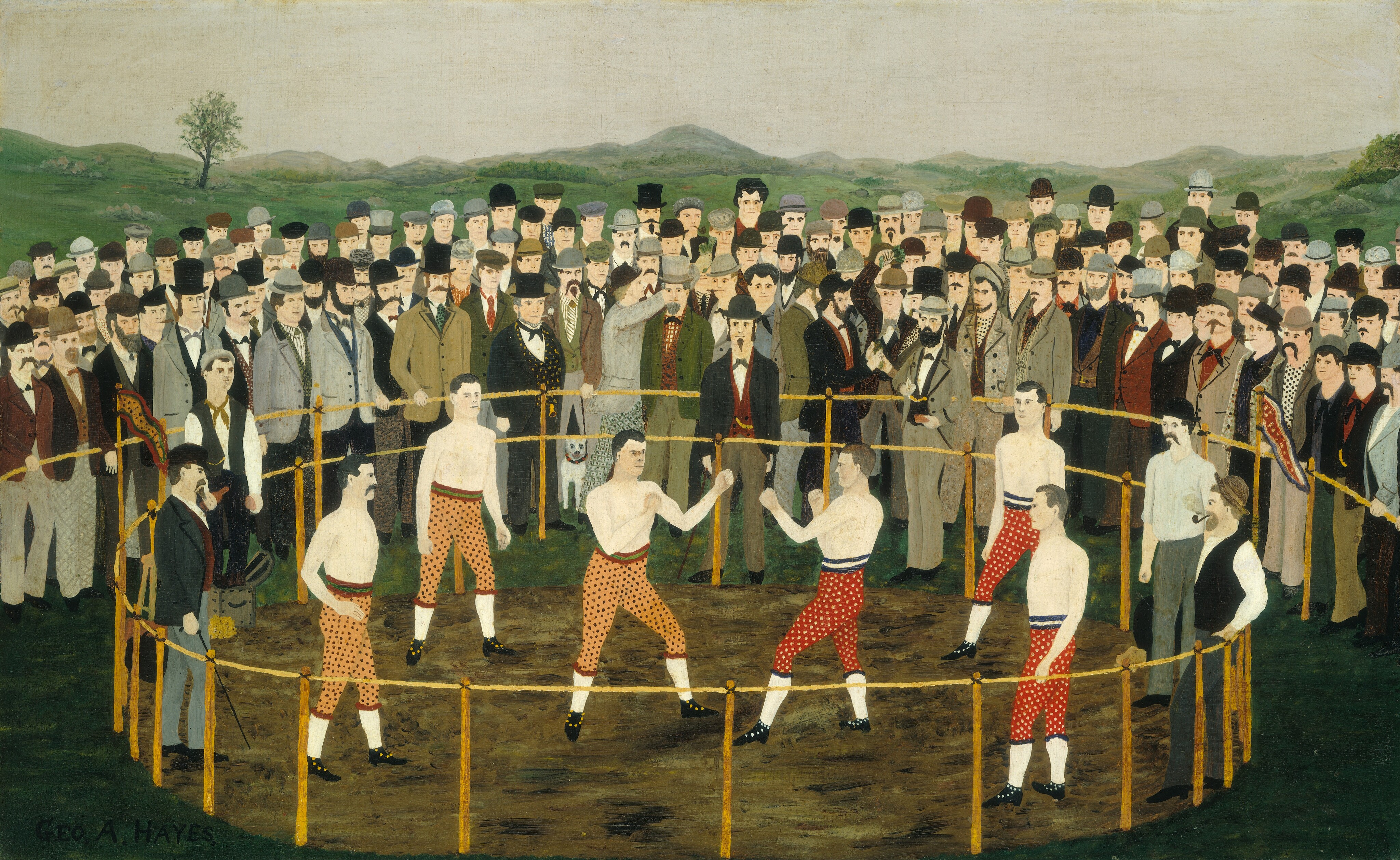 This is a painting depicting a bare-knuckle boxing match with two fighters in a ring surrounded by a crowd. Both fighters are men with light skin, and they wear no shirts. The fighter on the left wears orange pants with black dots, while the fighter on the right wears red pants with white dots. Behind these men are two other shirtless men wearing the same types of pants, as well as two other men wearing more formal attire, including jackets, vests, and hats. Outside the ring, a semi-circle of light-skinned men in formal attire watch the central fight. The setting is outdoors, with grass around the feet of the spectators and green hills in the background. Above the group, the sky is light gray.