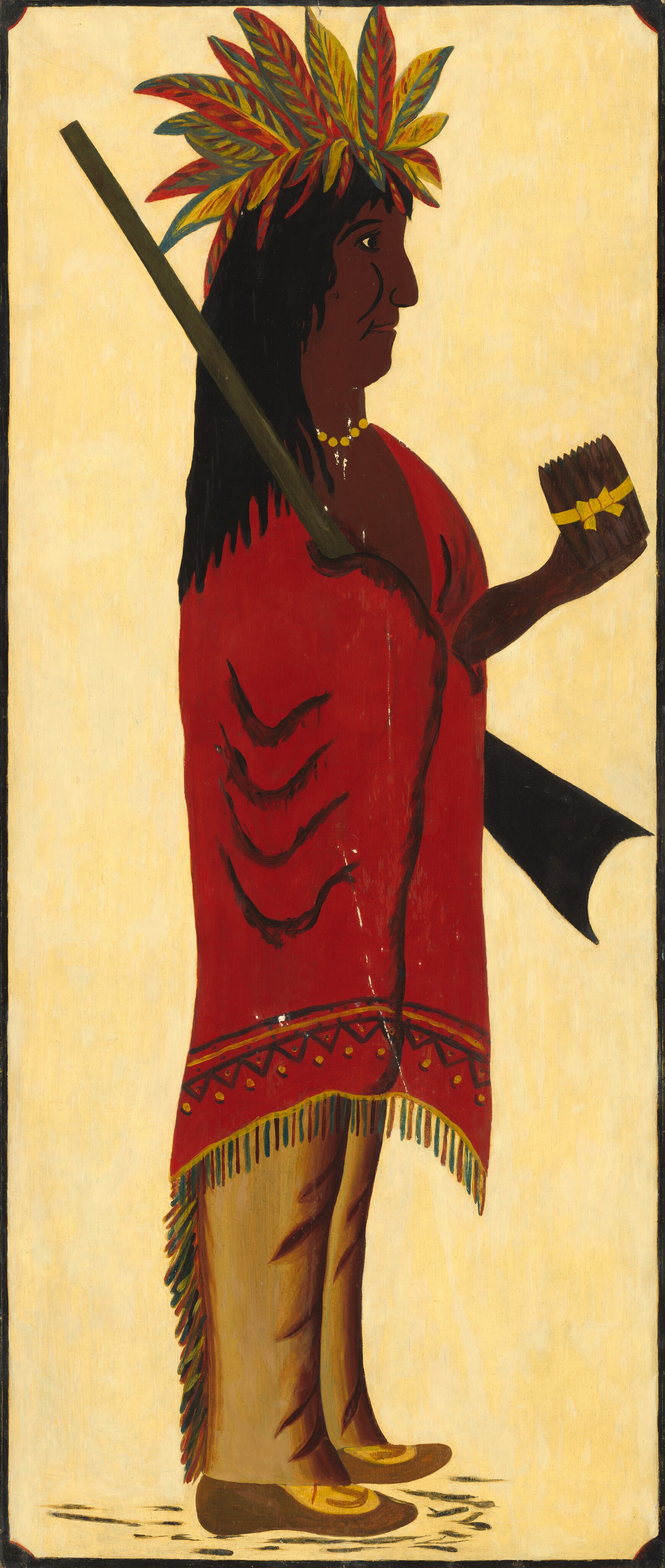 The image shows a person in profile standing upright and facing to the right. The individual has dark brown skin, long black hair, and wears a headdress made of colorful leaves. They hold a cylindrical object with a yellow ribbon in their left hand. The person wears a red garment with black markings and geometric patterns, along with tan pants and moccasin-like shoes. They also wear a yellow necklace around their neck. The background is a plain, solid light color.