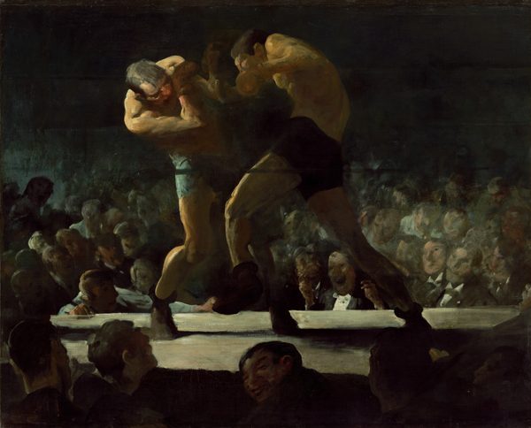 Two men wearing brief-like shorts, shoes, and boxing gloves curl toward each other as they grapple in the middle of a boxing ring in this horizontal painting. We look at the ring from across the heads of the crowd below and around us. The platform of the boxing ring comes about a quarter of the way up the canvas so the boxers themselves nearly brush the top edge of the composition. The boxer on our left has pale, peach skin and wears light blue shorts. He curves to his side as he dips his head and right shoulder toward us in a defensive position, arms shielding his face. To our right and in the center of the composition, the opponent has an olive-toned complextion. He wears dark shorts and is shown in mid-punch with his left leg raised to step forward. His back curves like a comma as his right arm comes forward with the punch. Bright light, like a spotlight, illuminates the men from our left so even the right sides of their bodies are lost in shadow. The crowd around us is backlit but one grinning man turns to look over his shoulder at or beyond us. The arena across the boxing ring is also plunged into deep shadow, so only the faces in the first few rows are visible before being swallowed in darkness. In fact, the top third of the canvas behind the boxers is black. The faces of the men in the crowd across from us are loosely painted, sometimes with only a few strokes to capture features. Individual features are mostly obscured but one face near the center, between the legs of the attacking boxer, is split wide in an exaggerated grin. That man wears a white tuxedo shirt and black jacket, and raises both hands, as if ready to light a cigar.