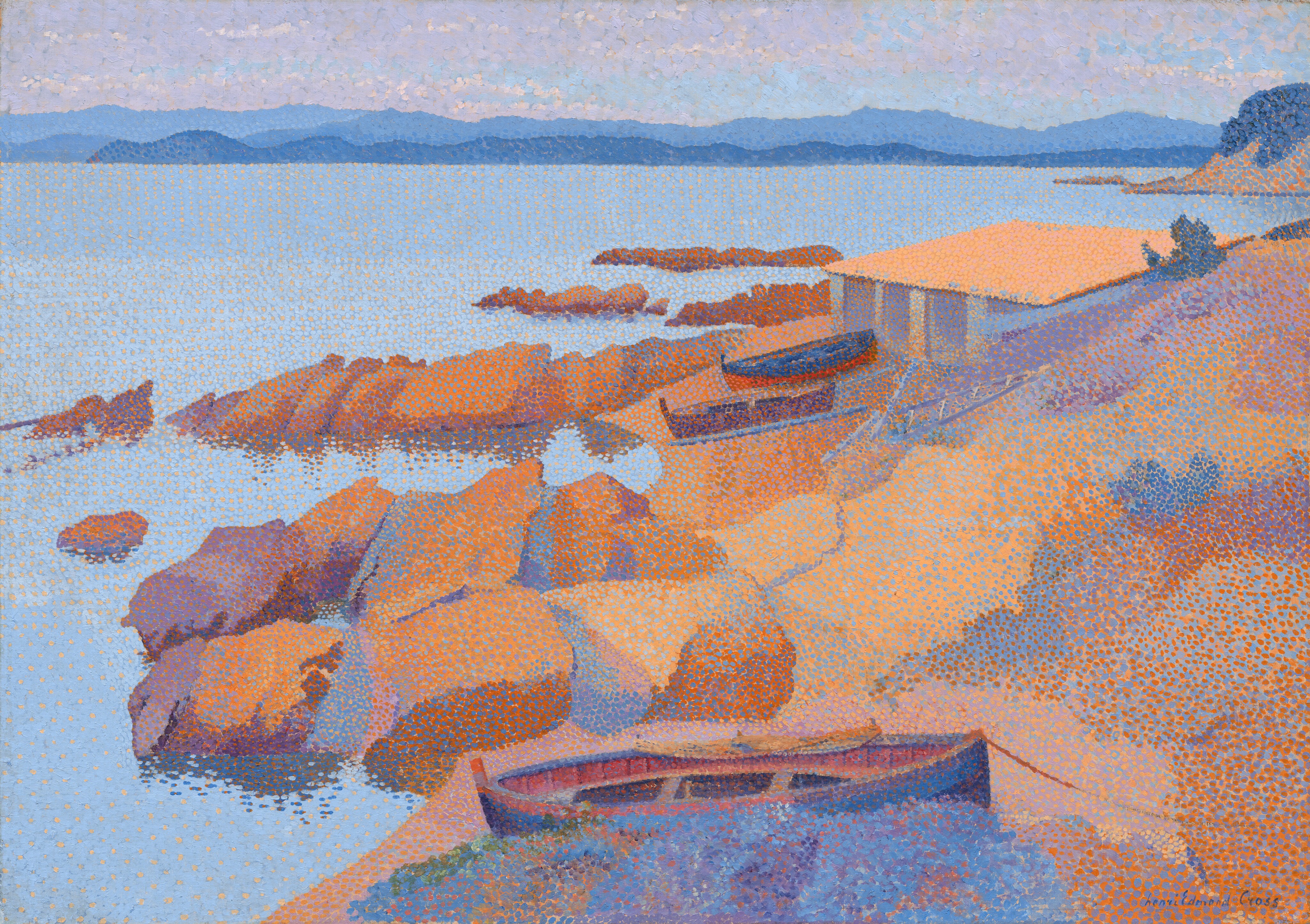 The painting depicts a coastal scene. A rocky shore in warm tones of orange, brown, red, and purple is closest to us, with two boats and a simple structure visible near the center of the painting. There is another boat closer to us, by the water near the bottom edge of the painting. The horizon line is almost at the top of the painting, with a range of mountains faintly visible against a strip of pale-purple sky, past the large body of water. The water is a light blue color, stretching from the rocky shore on the right to the distant mountains. The paint has been applied with small dot-like brushstrokes of reds, oranges, blues, and purples.
