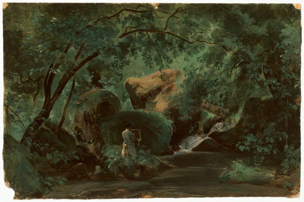 Boulders hulk at the center of a dense forest in this horizontal landscape painting on paper. A clearing along the bottom edge of the composition leads to a person facing away from us while standing at an easel. One hand is lifted to the canvas or paper on the easel, and the person wears a light gray coat. A light brown dog sits attentively at the artist’s back. Sunlight falls from an unseen opening in the canopy onto the boulders, which glow caramel brown and slate gray, and trees curve up and over to enclose the artist and rocks. The scene is loosely painted in earthy greens, and brushstrokes are especially visible in the boulders and the vegetation making a screen in the background.