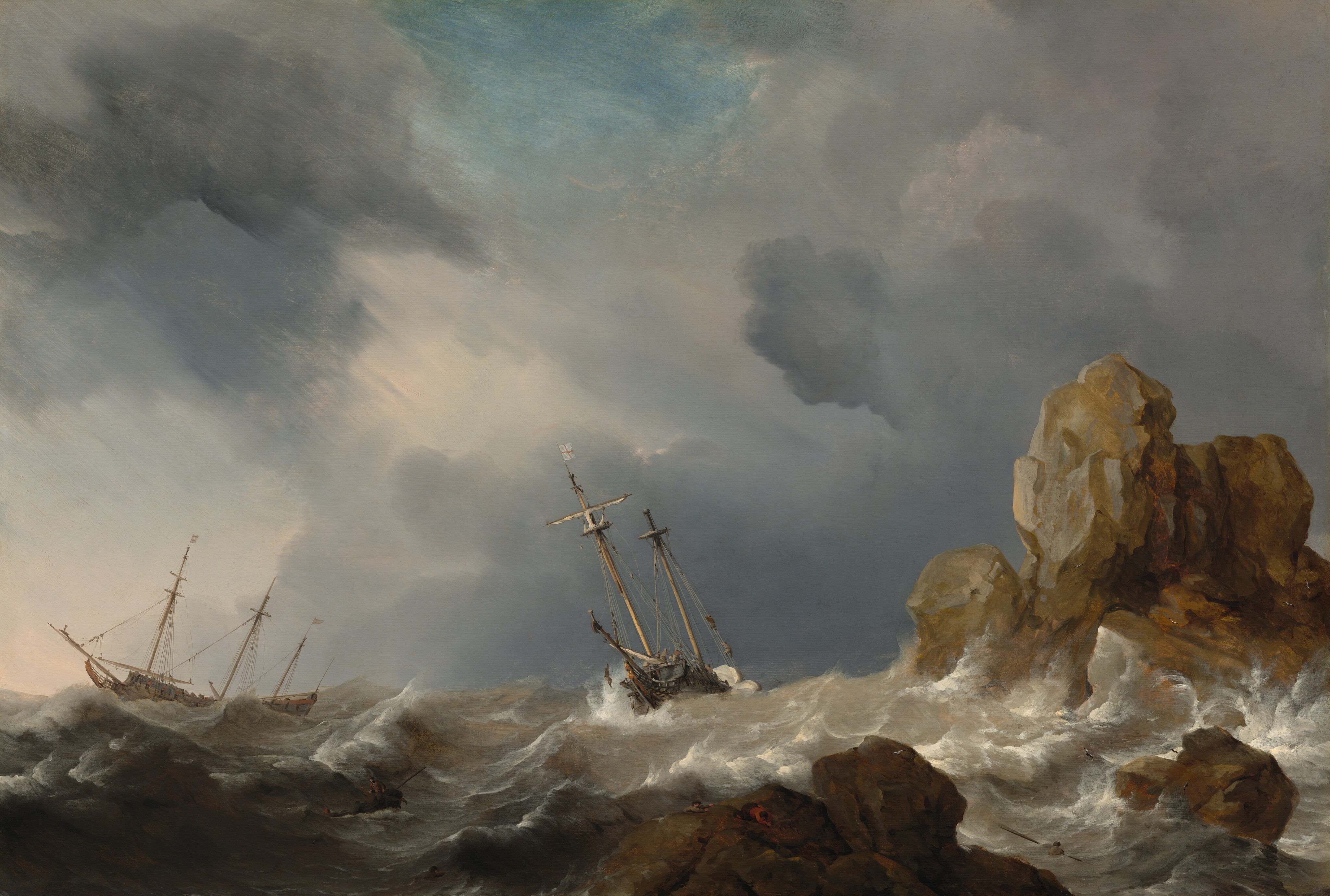 Amid the white crests of gray, churning waves, two masted ships tip wildly near a rocky outcropping beneath slate-gray and lavender-purple clouds in this horizontal landscape painting. The horizon comes a quarter of the way up the painting, and the ships are outlined against the clouds, which sweep across the sky from the lower right to the upper left corner. A patch of topaz-blue sky shines through at the top center of the painting. The long side of the three-masted ship to our left faces us and flags, possibly white with red stripes, fly from two of its masts. The ship at the center of the painting is angled toward us and a single white flag with a red cross flies from one of its two masts. Tiny in scale, people are gathered on the decks and climb the rigging alongside the masts. On the boat at the center, one person hovers overboard, perhaps holding onto a rope or shown falling to the sea. Foamy waves lap at the tall, jagged rock formations to our right, which jut out of the ocean like teeth. The largest boulder, near the right edge of the painting, is painted with tones of golden tan and silvery gray, suggesting it catches sunlight. The lower rocks, closer to us, are in shadow and painted coffee brown and iron gray. Upon closer inspection, two people climb onto the jagged rock closest to us. More scrutiny reveals several people in a rowboat and two men in the water around the rocks. A few birds, minuscule against the waves, fly over the rocks.