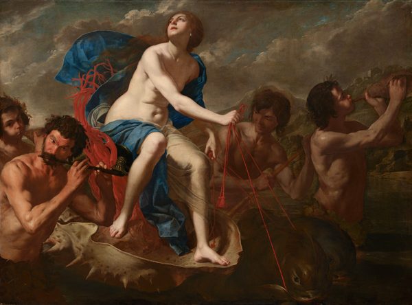 A nearly nude, pale-skinned woman rides an oversized seashell being pulled by stylized dolphins in this horizontal painting. Four muscular, tanned men with dark, unruly curly hair surround the shell and play music. The woman sits on a seat made by twisting red coral with her body angled to our right. She turns her face up and to our left, to the sky. She has dark eyes and brows, a heart-shaped face, a cleft in her chin, and her pink lips are parted. Her auburn-brown hair appears gathered at the base of her neck and long tresses lift in the breeze over her right shoulder, to our left. A teardrop-shaped pearl hangs from the ear we can see. A celestial-blue cloth and a translucent white veil wraps over one shoulder and flutters behind her. The cloth then drapes across her back and over her thighs, exposing her soft tummy and rounded hips. The fish-like dolphins pulling the shell have rounded heads and black, glassy eyes. Short fins run the length of their curved backs over dark, olive-green skin. The woman guides them using red, twisted cords looped through their mouths. A pair of musicians are to each side of the shell. To our left and in the lower corner, one man holds a flute to his lips. The outer corners of his eyebrows arch up under a lined forehead. A ring of broad leaves wraps around his waist. Another man behind him blows with cheeks puffed into a shell as he looks at us. In the pair to our right, on the far side of the shell, one man holds a stick, perhaps guiding the vessel, while another, at the front of the grouping, blows into a shell. The man at front wears rings of leaves around his head and waist. The scene is lit starkly from our left, illuminating the woman and casting the rest into shadow. The water around the group is dark, pine green. Rocky mountains dotted with trees and buildings rise in the distance. Ash-gray clouds create diagonal bands moving up and to our right against a muted blue sky.