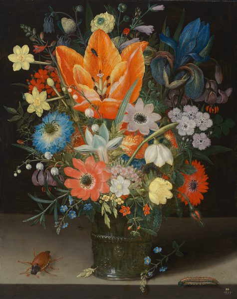 This painting shows a bouquet of various colorful flowers bursting out of a glass vase. A large, bright orange lily is at the center, surrounded by a variety of large and small flowers in red, white, blue, yellow, and pink, with a large blue iris in the top right corner. Some flowers are drooping over the top of the vase, and a few small ones have fallen to the table below. The glass vase is packed with the long green stems of the flowers, giving it a green appearance. The vase rests on a light gray table, and there is a brown beetle on the left and a caterpillar on the right, near the edge of the table. The wall behind the flowers is black.