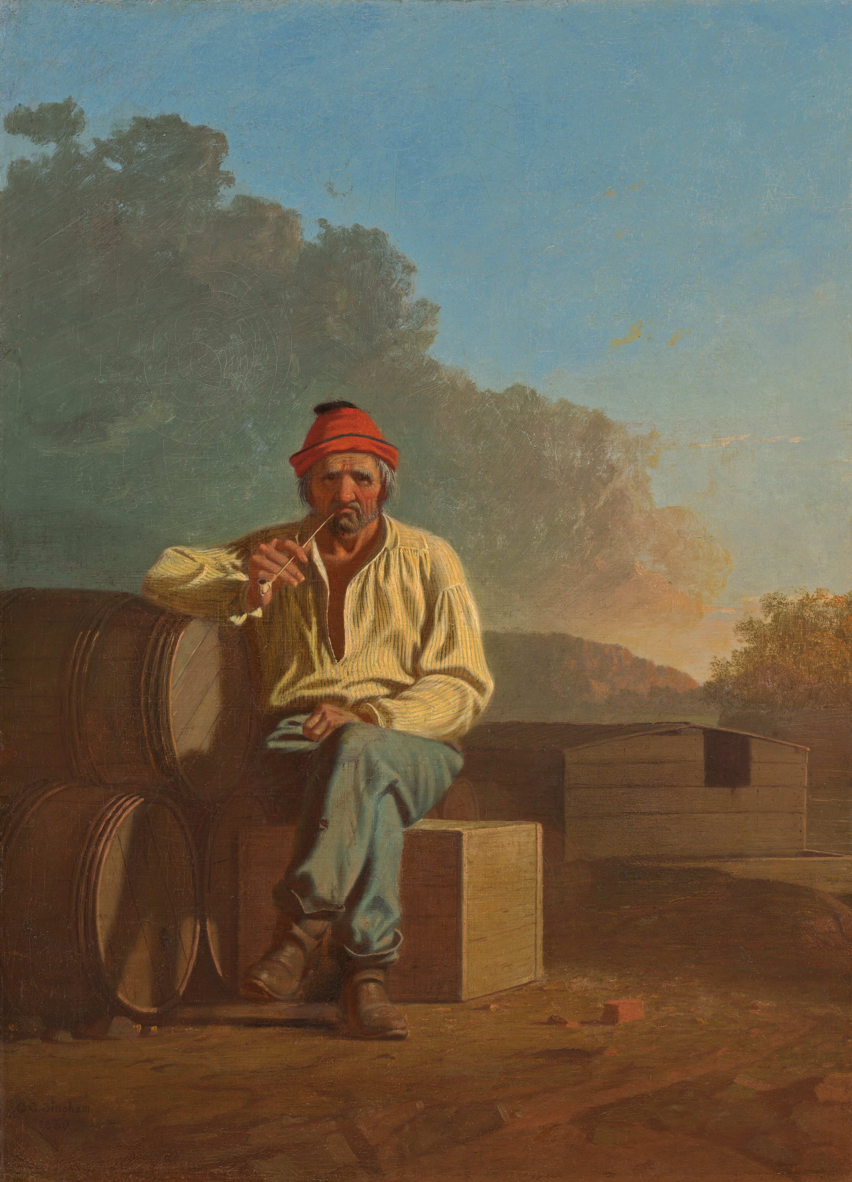 A bearded man with wrinkled, peachy skin and reddened cheeks sits and smokes a pipe on a wooden box in a landscape in this vertical painting. The man’s body faces us, and he peers at us with dark eyes under heavy, bushy white brows. Wrinkles line his forehead, the corners of his eyes, and his cheeks. He has a bulbous nose and a gray beard, and the long-stem pipe is pinched in his downturned mouth. His shaggy gray hair is covered by a cardinal-red cap. He wears a blousy daffodil-yellow shirt, which is loose around the neck, faded and patched blue pants, and scuffed brown boots. His legs are crossed with one knee over the other, and one fist rests in his lap. The other elbow is propped on a pyramid of three wooden barrels stacked on their sides to our left. A few bits of bricks or red stones are near the man’s feet, and a wooden houseboat with a low-pitched roof is in the near distance, to our right. The platform under the structure floats on a river, which is lined with trees to our right and mountains to our left. The sunset warms the face of the mountains and the trees to red and gold. Sage-green and peach clouds billow above the man, dividing the sky diagonally in front of bright blue sky beyond. The artist signed and dated the painting in the lower left corner, “G.C. Bingham 1850.”