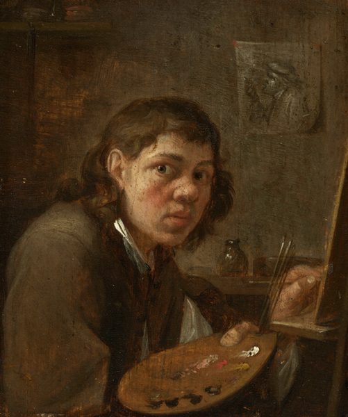 This painting shows the upper body of a person seated at an easel. The individual is looking towards us, with their body facing the easel on the right. They have medium-length brown hair, a round, pale face, and dark eyes. The person is wearing a brown garment over a white shirt, holding a wooden palette in one hand with paint and paintbrushes. Their other hand is lifting a brush to the easel. In the dark gray background, there are indistinct objects on a shelf and a sketch pinned on the wall depicting another person in a profile view, turned to the left.