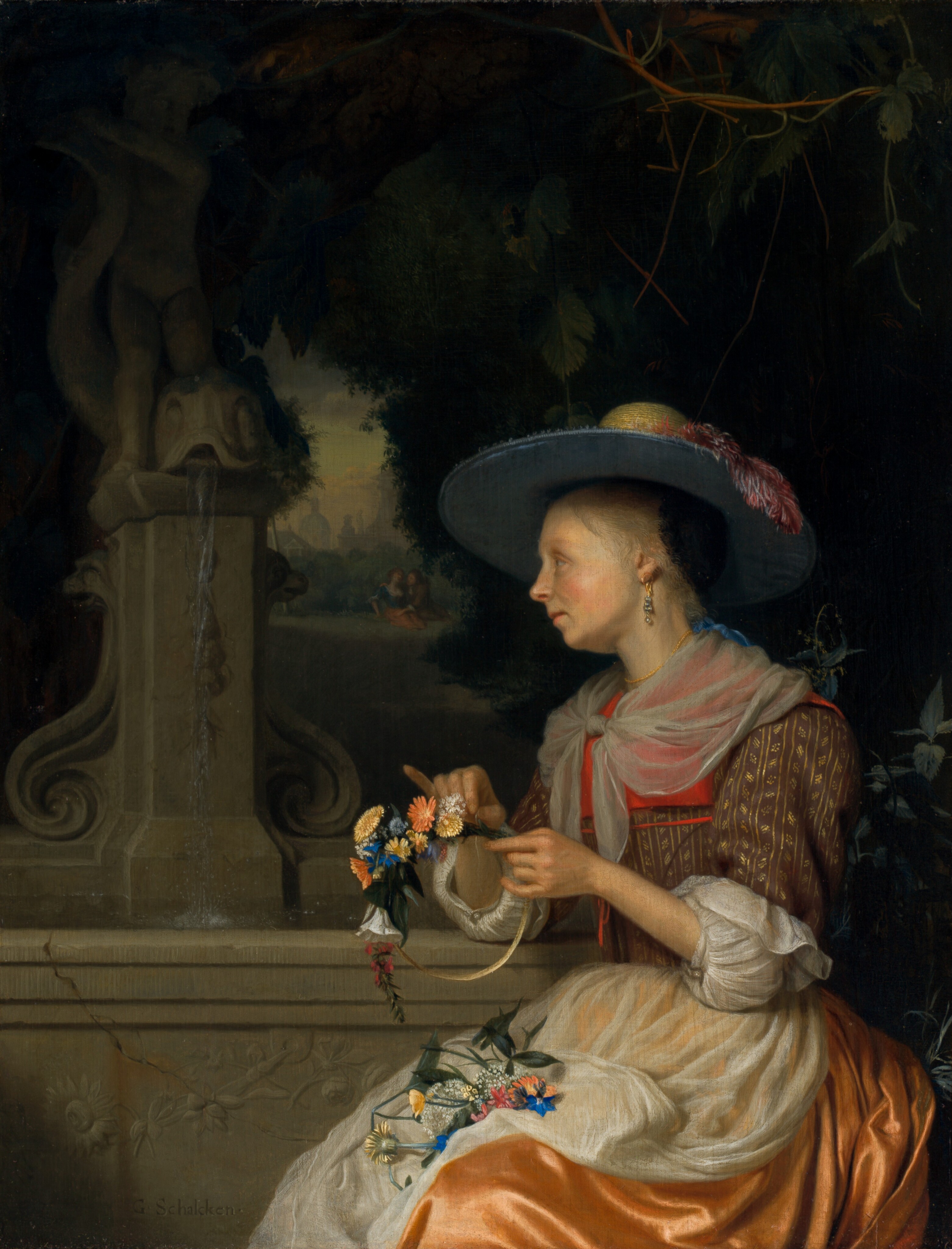 Shown from the lap up, a pale-skinned woman wearing a long gown and wide-brimmed hat sits in front of a low stone wall in this vertical portrait painting. The woman takes up the lower right quadrant of the composition. Her body faces our left, and she looks off in that direction so we see her in profile. She has large eyes, a delicate nose, round, flushed cheeks, and a pointed chin. Her blond hair is pulled back under a black covering at the back of her head. The underside of her hat brim is steel gray, and a carnation-pink feather droops over one side. The rounded, straw-yellow crown is just visible above the grim. A gold and pearl earring dangles from the ear we see, and a smoke-gray, translucent cloth is tied around her shoulders. The bodice of her dress is coral red on the upper chest and patterned with gold stripes and leaves against brown on the torso and elbow-length sleeves. The white garment she wears underneath is gathered in puffs just under the elbows, beyond the end of the brown sleeves. Her apricot-orange skirt has a sheen, suggesting satin, and a translucent white apron is tied around the waist. She holds a hoop, about the diameter of a human head, in both hands. She adds colorful flowers to the hoop and more blossoms lie in her lap. Her far elbow rests on the stone wall that spans the bottom third of the painting. The front face of the wall is carved in low relief with a sunflower, roses, and other flowers. A crack runs down through the top of the wall and curves toward the woman. A stone fountain rises from the ledge to our left. A tall base is topped by a stylized fish with water trickling from its open mouth. Also part of the carved fountain, the head of a small child standing astride the fish is cut off by the top edge of the panel. Shadowy trees nearly fill the space beyond the wall, but a clearing is visible through a small gap near the woman’s face. There, a man sitting on the grass wraps his arms around the woman sitting next to him. A dome, towers, and rooflines are nickel-gray in the deep distance beyond. The artist signed the work as if he had carved the wall near the woman to read, “G. Schalcken.”