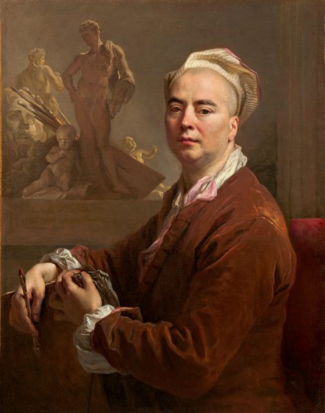 The image shows a portrait of a man visible from the waist up, seated in a red cushioned chair, his body turned to the left and his face turned to us. His facial features include pale skin, dark eyebrows, slightly sagging cheeks, and pink lips in a neutral expression. His hair seems to be shaved, and his head is mostly covered by a white, striped head covering that resembles a beret. He wears a reddish-brown coat with white ruffled sleeves, and underneath a white collared garment and a light pink ribbon peek out. In his hands, the man holds drawing instruments, including a pencil or pen and a stack of papers. Behind him on the left are several small tan and white sculptures, including a nude male figure, a cherub, and a woman's head. Beside these sculptures are several paint brushes and a flat surface that could be a painter's palette. The walls behind him are gray.