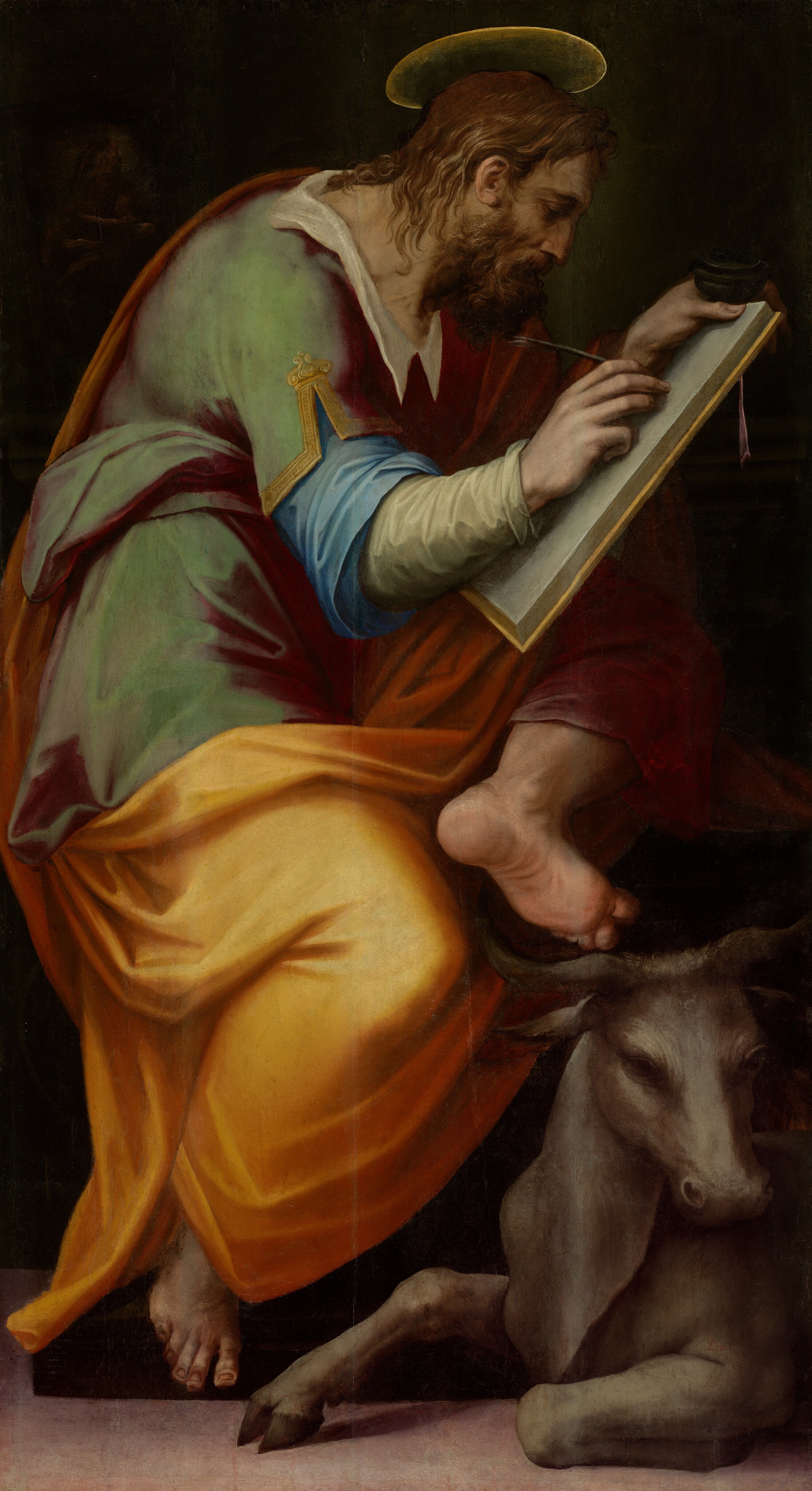 A pale-skinned man sitting hunched over as he draws on a tablet and a bull lying at his feet fill this vertical painting. The man faces our right in profile, and he looks down at the book. He has a lined forehead, a bumped nose, and wrinkles around his nose. He has lanky, chin-length hair and a curly, unruly beard. He sits with one leg pulled up so he can partially brace the tablet on that knee. He holds the inkwell and clutches the top of the tablet with one hand and draws using a feather quill with the other. His other leg stretches down, and the ball of the bare foot is perched against the edge of the low platform on which the man sits. His garment has a white collar over a tunic that shimmers from plum purple to moss green. Extending from under the tunic’s short sleeves are long sky blue and pale laurel green sleeves. A golden yellow robe drapes over one shoulder and wraps around his lap. The gray bull, which is shown in about half the scale of the man, sits with one front leg tucked under his body as he looks over to our right. The floor is pale mauve purple, and the background is dark green, almost black. A glimpse of a work of art showing a woman holding a baby is visible near the top left corner of the painting.