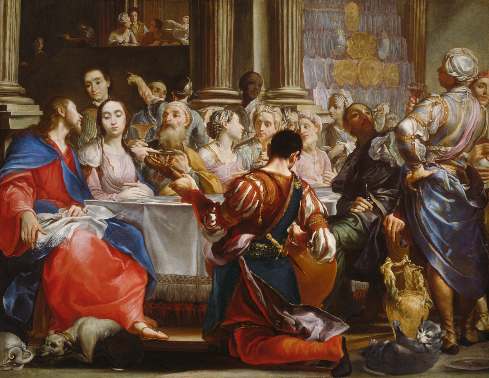 Painting of a lively wedding reception with a man in red kneeling in front of a table. The wedding party is dressed in pale pink clothes and seated.