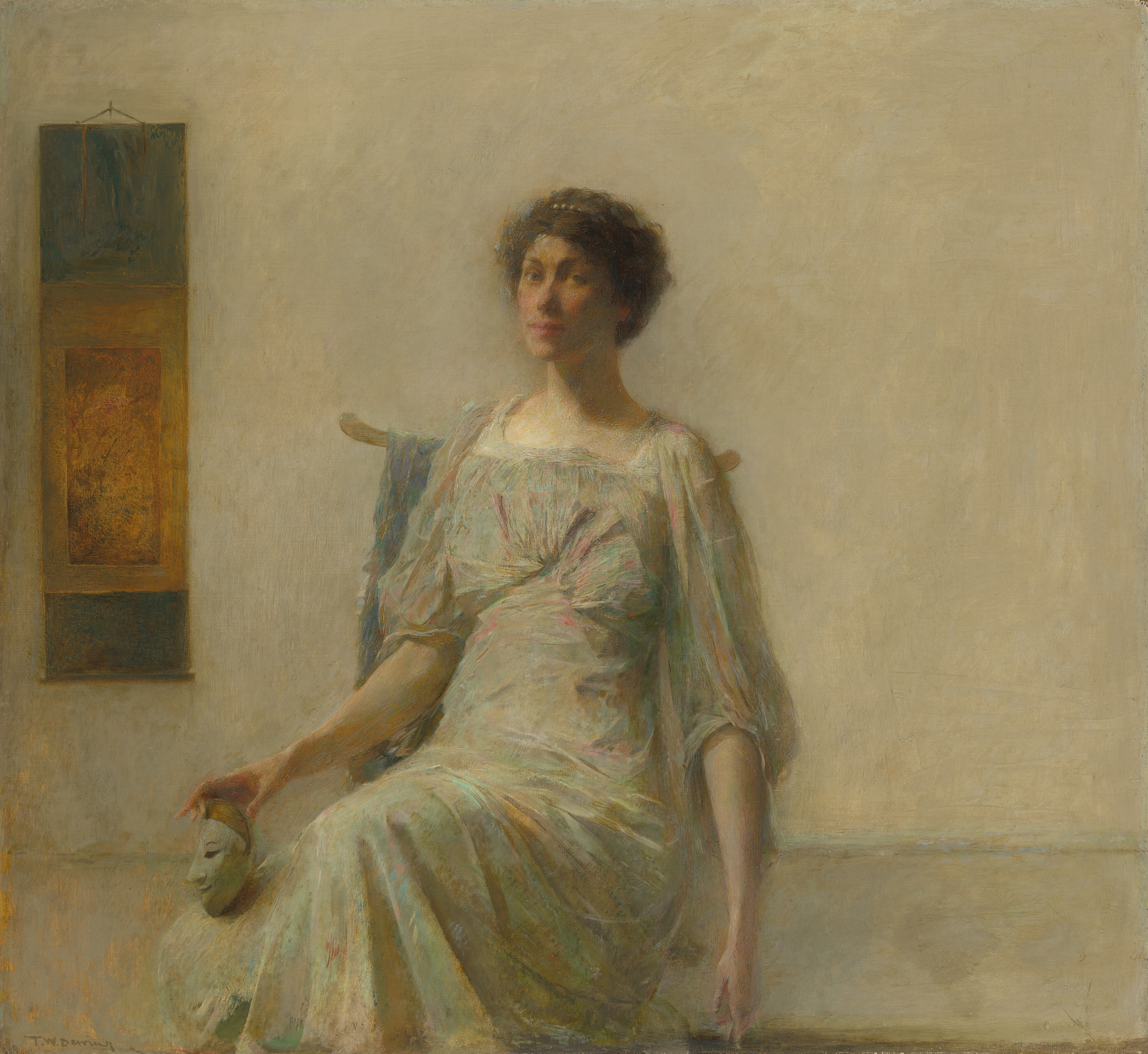 This painting shows a seated woman, her body turned slightly to the left and her head turned towards us. She is holding a small white mask in her right hand, balancing it on one of her knees. She has pale skin, high cheekbones, and pink lips in a neutral expression. She has short, dark, curly hair that is adorned with a pearl clip or headband. She is dressed in a light-colored gown with highlights of pink, green, and pale blue, with wide, flowing sleeves and fabric gathered at the bust. The background is a plain gray wall, with a hanging scroll or tapestry beside her on the left, containing shades of blue and gold.