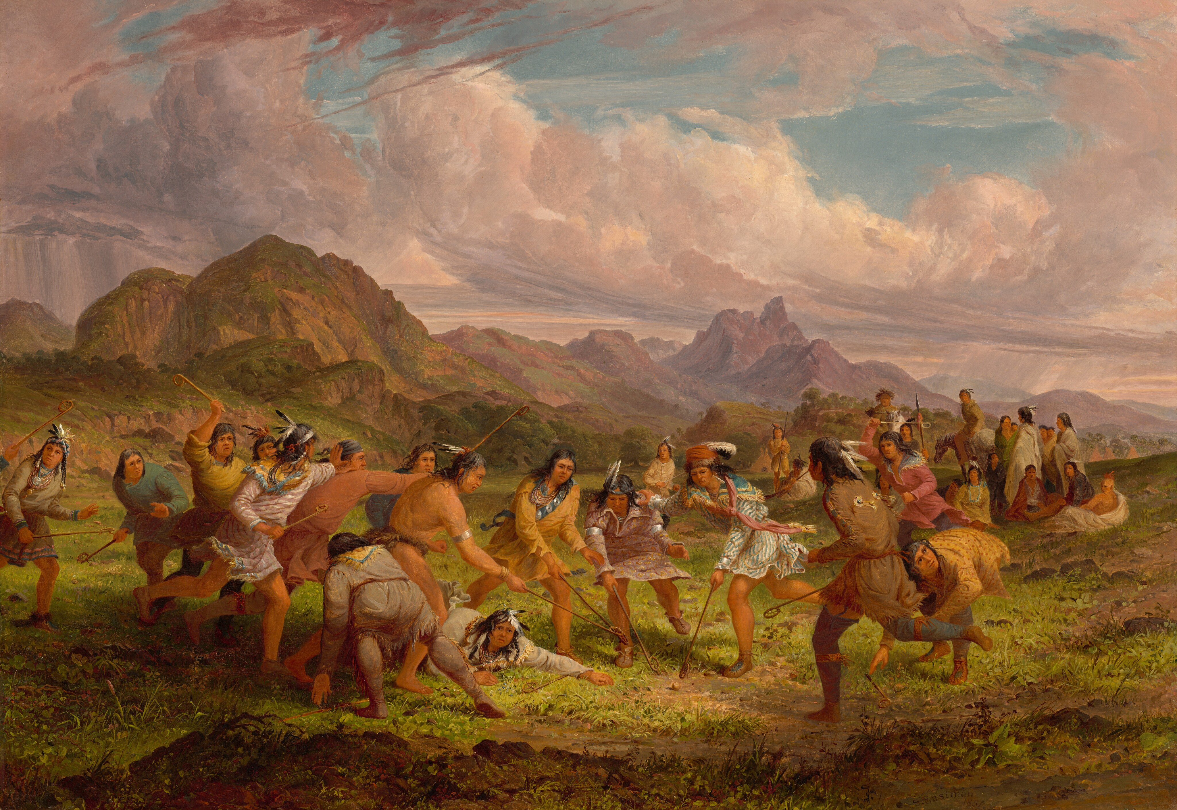 This painting shows a scene with people engaged in a sport or game. The people wear vibrant clothes in shades of brown, orange, yellow, pink, and green, embellished with feathers and silver jewelry. The people all have light brown skin and long dark hair, and many of them have feathers in their hair. All the people in the middle of the painting hold sticks with small nets at the end, and they all appear to be lunging towards a small ball on the ground. In the background is a dramatic landscape with tall purple mountains, green hills, and large pink-and-white clouds sweeping across the blue sky.