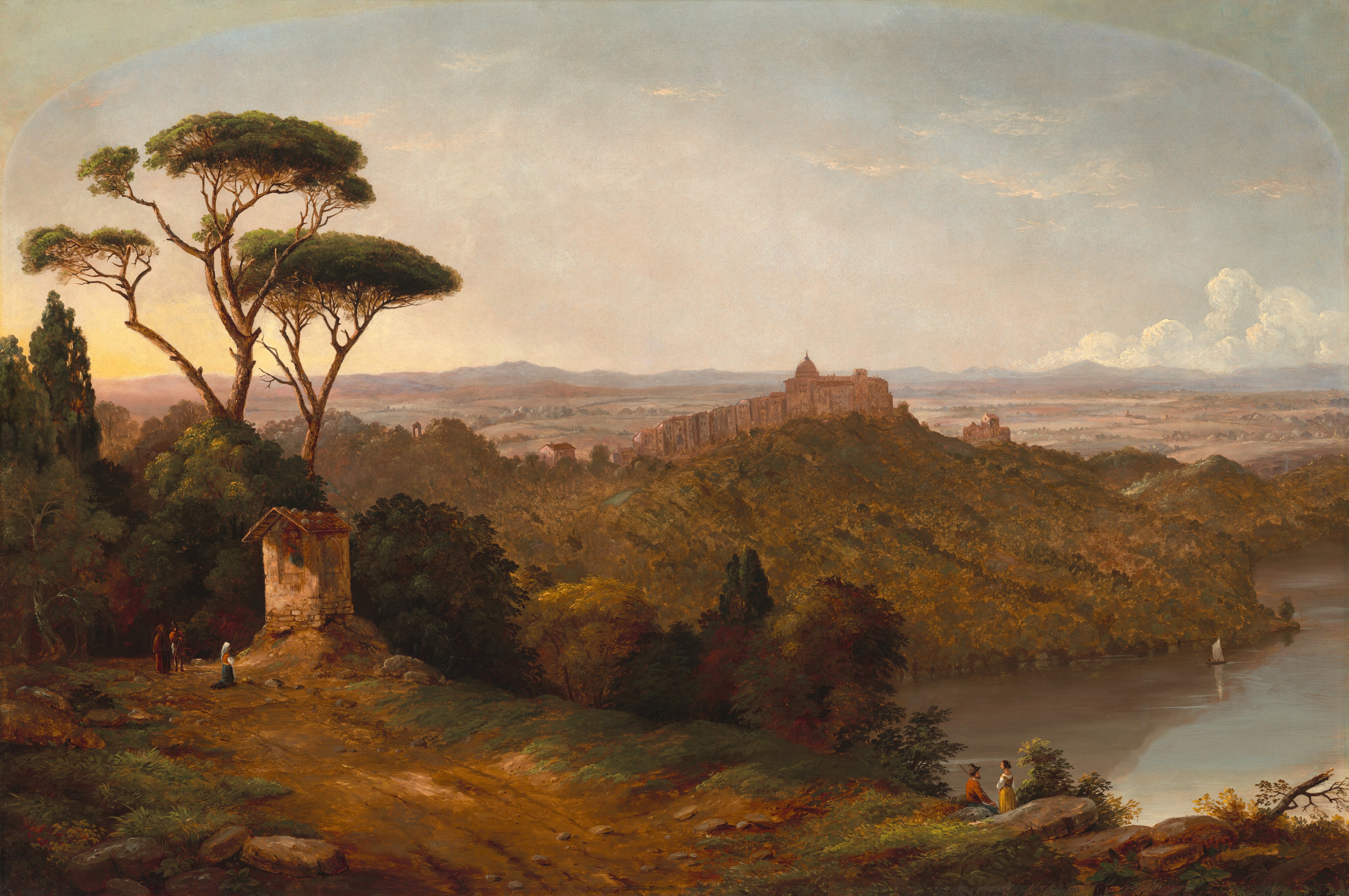 From a high vantage point, we look across hills, trees, and a body of water and into the deep distance in this horizontal landscape painting. A shed-like structure with an overhanging roof protecting an image of a woman holding a baby is near the left edge of the composition. In front of the structure, a person wearing a white head covering, red vest, white sleeves, and long blue skirt kneels on the dirt path, and a basket of flowers is near her knees. Two other people, all tiny in scale, stand nearby. One of them wears a brown cape, cassock, and hood, and the other wears a high-crowned hat, a red coat, gray pants, and holds a walking stick. Across the composition, a man sits and a woman stands, facing each other, on the far side of a boulder in the lower right quadrant of the painting. The man wears a burnt-orange jacket, slate-blue pants, a high-crowned hat, and holds a long staff. The woman has brown hair and wears a yellow dress over white sleeves and white lining across the neckline. They both have pale, peachy skin. A sailboat is reflected in the placid body of water that lies far below us, and a complex of buildings tops the hill on the opposite bank. The peanut-brown land flattens and ripples gently back to pale blue mountains lining the horizon, which comes just over halfway up this composition. White clouds pile up over the right side of the horizon, and a few thin clouds drift higher up. The upper corners of the canvas are darkened, suggesting that at one point this was displayed with an arched top. The artist signed and dated the painting as if he had written the information on the face of rocks in the lower right corner: “C.P. CRANCH 1852.”