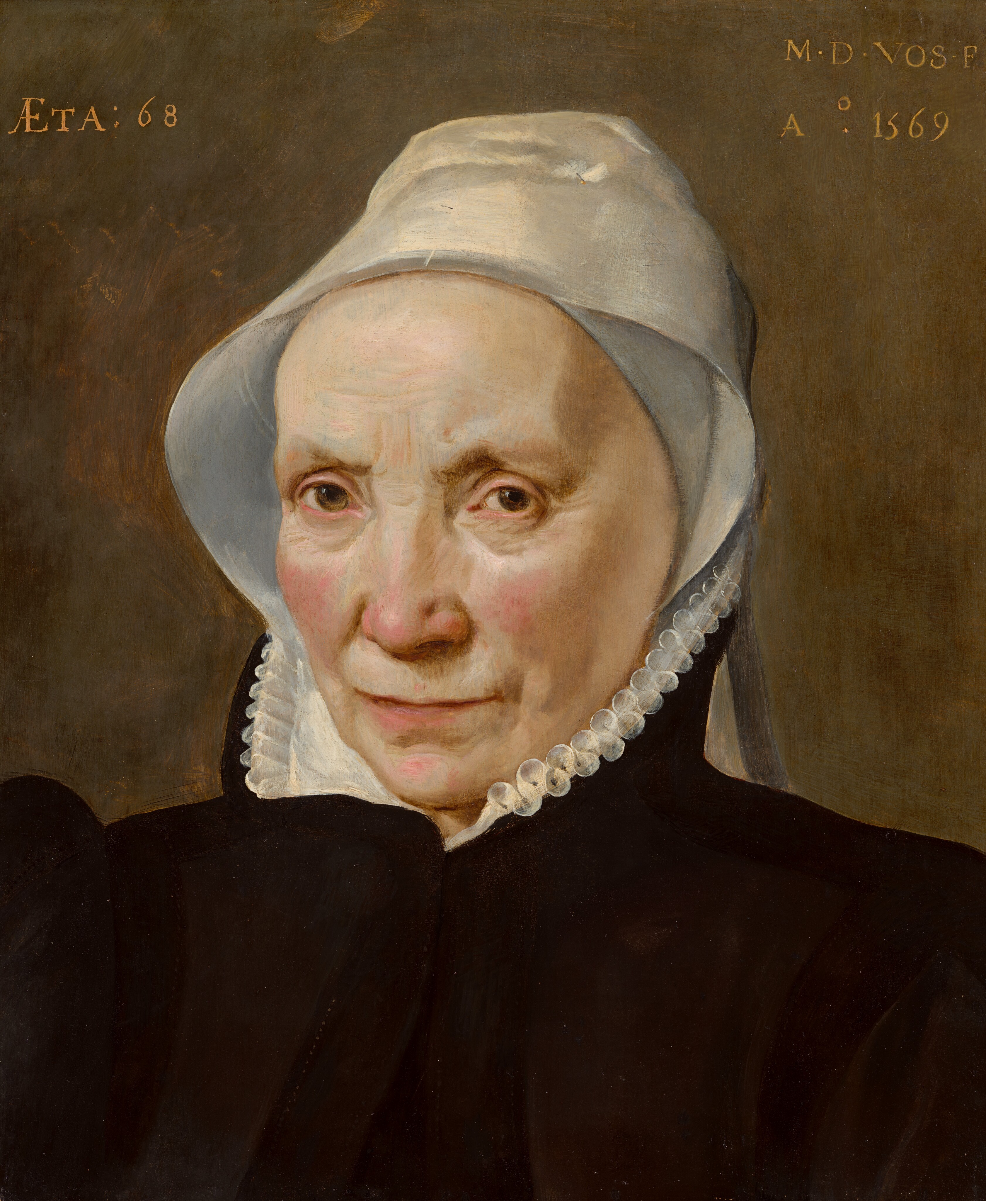 This painting depicts an older woman from the chest up, looking toward us. She has a fair complexion, with wrinkles on her forehead, deep-set brown eyes, and thin, pink lips. She is wearing a white cap and a black garment with a white ruffled collar. The background is a mottled, muted brown. There is a small amount of text in the top left and right corners.