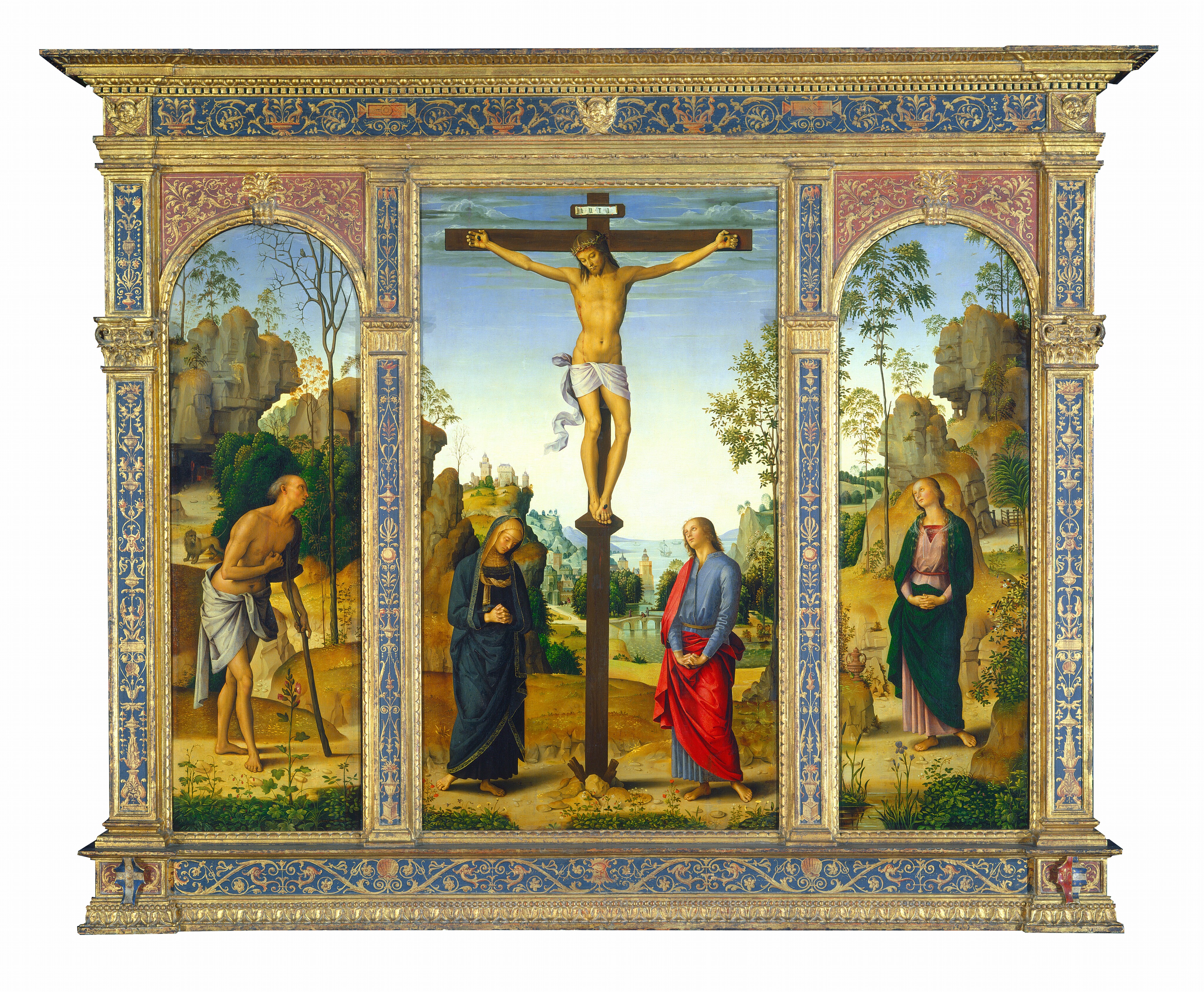 One tall, rectangular panel is flanked by arched panels to each side, all set within a carved, painted, gilded wooden frame. The central panel shows two people at the foot of a wooden cross, to which a man is nailed, and the panels to each side are each occupied by a single person. All the people have pale skin and are shown against landscapes with rocky outcroppings along a river that extends into the deep distance. At the center of the middle panel, the man hangs from the cross from nails in his hands and one nail driven through his overlapping feet. He is nude except for the white loincloth wrapped around his hips, which falls in fluttering ripples alongside his right leg, on our left. Blood drips down his forehead from where a ring of thorns encircles his shoulder-length, chestnut-brown hair. His head tilts to his right, our left, and his eyes are closed or downcast. Blood also drips from his hands and feet, and from a slit over his right ribcage. The woman standing to our left of the cross wears a navy-blue robe edged in gold that covers her head and drapes to her ankles above bare feet. Her head tips down to our right, and she holds her hands clasped loosely, fingers intertwined, at her waist. The person standing to our right of the cross wears a cobalt-blue robe under a vivid, scarlet-red cloak. He has blond curly hair and delicate features, like the woman. With arms nearly straight, he holds his interlaced fingers with palms facing down, close to his body. He looks up at the man on the cross. Low hills dotted with flowers and plants separate the people from a river that runs between rocky hills and outcroppings. Stone buildings line the bank beyond a bridge spanning the river in the distance, and three boats sail near the horizon line, which comes halfway up the composition. The hills and mountains look green and then blue in the deep distance under a sky that fades from nearly white along the horizon to pale, topaz blue along the top edge of the panel, which is also lined with clouds. In the panel to our left, a balding man with gray hair leans on a wooden staff like a crutch, nearly in profile facing our right. He also is nude aside from a slate-gray cloth that wraps around his hips. He holds his loosely fisted right hand up to his chest. A lion stands in front of a cave entrance behind the man. In the panel to our right, a woman wears a mauve-pink dress under a pine-green cloak. She holds her hands clasped with fingers interlaced at her abdomen. A small, gold-colored jar with handles sits on a rock to our left. Both the man and woman in the side panels look up toward the man on the cross. The landscape behind those in the side panels enclose each scene with rocky outcroppings that seem closer to us than the landscape in the central panel. More plants and flowers, and also trees, dot each landscape and soften the caramel-brown boulders with touches of moss and emerald green. The frame encasing the panels is carved and gilded gold around strips of aquamarine blue, which are painted with swirling tendrils, vines, urns, shells, animals, and some mask-like faces.