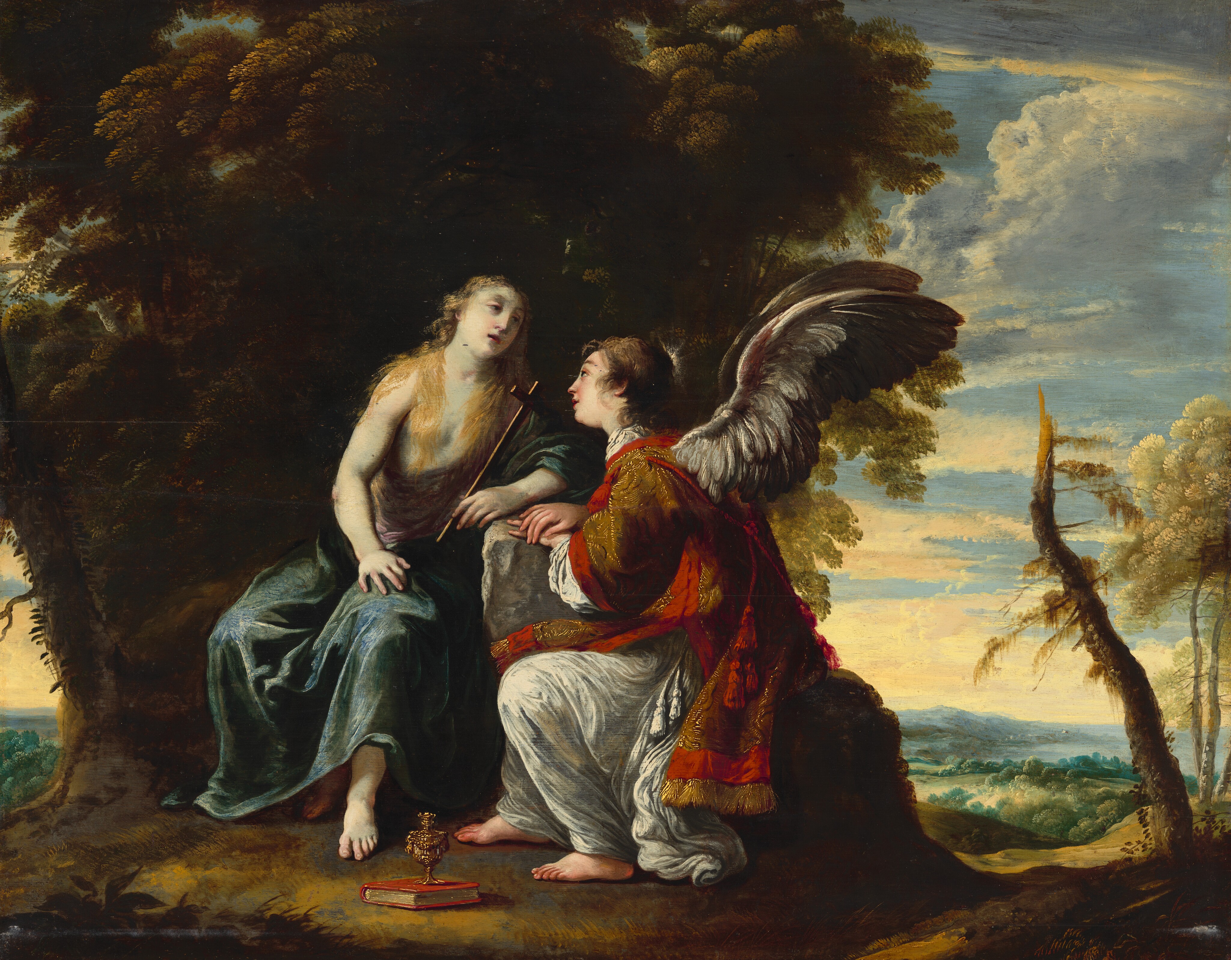 This painting depicts two people seated in an outdoor setting. The person on the left appears to be a woman with pale skin and long golden hair, wearing draped clothes in shades of lilac and teal. Her left arm is resting on a rock, and she holds a tall, thin cross. The person on the right sits on the other side of the gray rock, leaning towards the woman. They have white wings, pale skin, and short, curly brown hair. They wear a detailed red and gold garment over a long white robe. A small chalice and a closed book lie between the two people on the ground. In the background on the left there are tall, dark trees, while on the right are rolling green and blue hills under a bright blue sky with fluffy white clouds.