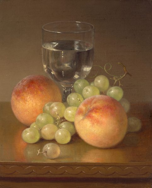 This painting is a still life composition with two peaches, a bunch of green grapes, and a glass of clear water on a wooden surface. The peaches are on the left and right side, the grapes are in the middle, and the glass of water is in the center and slightly towards the back. The peaches are painted in shades of pale yellow and orange, with hints of deep red, while the grapes are pale green with some hints of yellow or rose-pink tones. The clear glass and water in it are painted in shades of light gray with white reflections of light. The brown surface at the bottom of the painting reflects the colors of the fruit. The wall behind them is a light brownish-gray color.