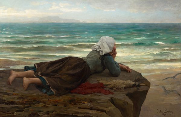 This painting shows a young woman lying on her stomach on a brown, rocky surface near the water's edge, looking towards the sea. The woman's bare feet are towards the bottom left corner of the painting, while her head is in the center, resting on her hand. She faces the right, and we see her back and side. She wears a pale green shirt with blue sleeves, a brown skirt, and a white cloth on her head. There is a red cloth on the ground next to her, as well as a pointed wooden stick that appears to be covered in white strips of cloth or feathers. The ground below her on the right is a tan, sandy color, and behind her is the sea, which is painted in vibrant turquoise and green shades, with white lines capping small waves. The sky is light blue with puffy white clouds, and distant landforms are visible in light gray across the water.