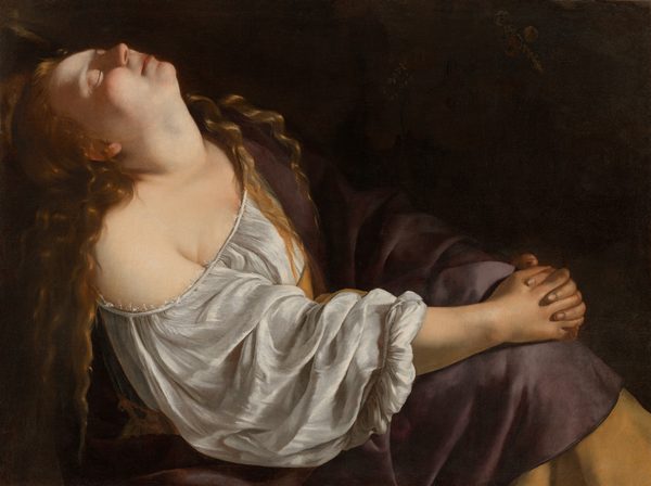 This painting shows a woman sitting with her body turned to the right, her hands clasped around her knees and her head tilted up to the ceiling. Her eyes are closed, and her long, wavy hair flows over her shoulders and down her back. She has pale skin, and her face is illuminated by dramatic lighting, highlighting her round cheeks and small nose. She is wearing a white blouse with ruffled sleeves that drapes off of her right shoulder, exposing her neck, sternum, and part of her shoulder. Over this shirt she seems to be wearing a draped purple garment with a yellow border that covers her other shoulder and her legs. The background is dark.