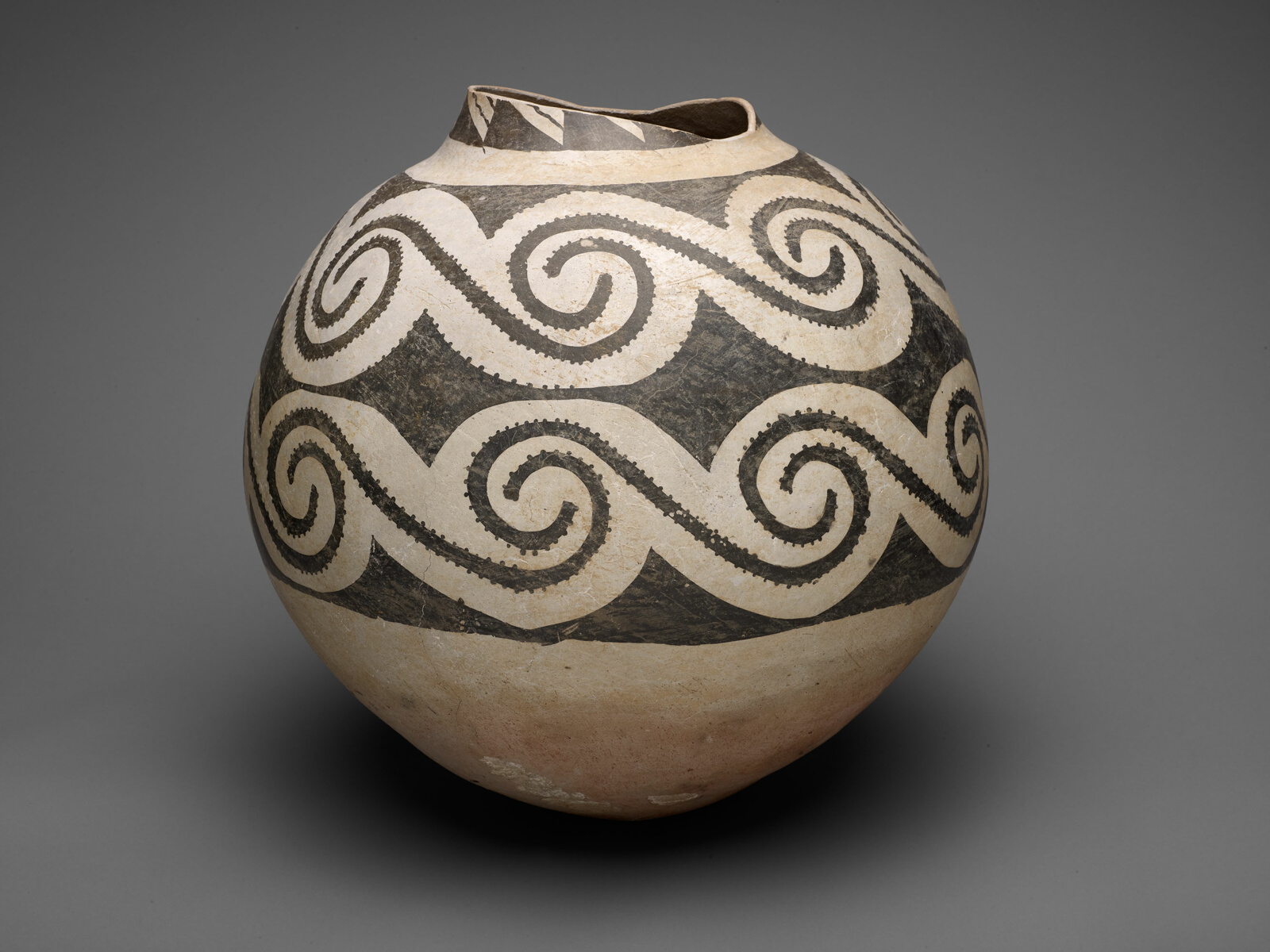 Round ceramic jar with large black S-shaped geometric designs on cream ground.