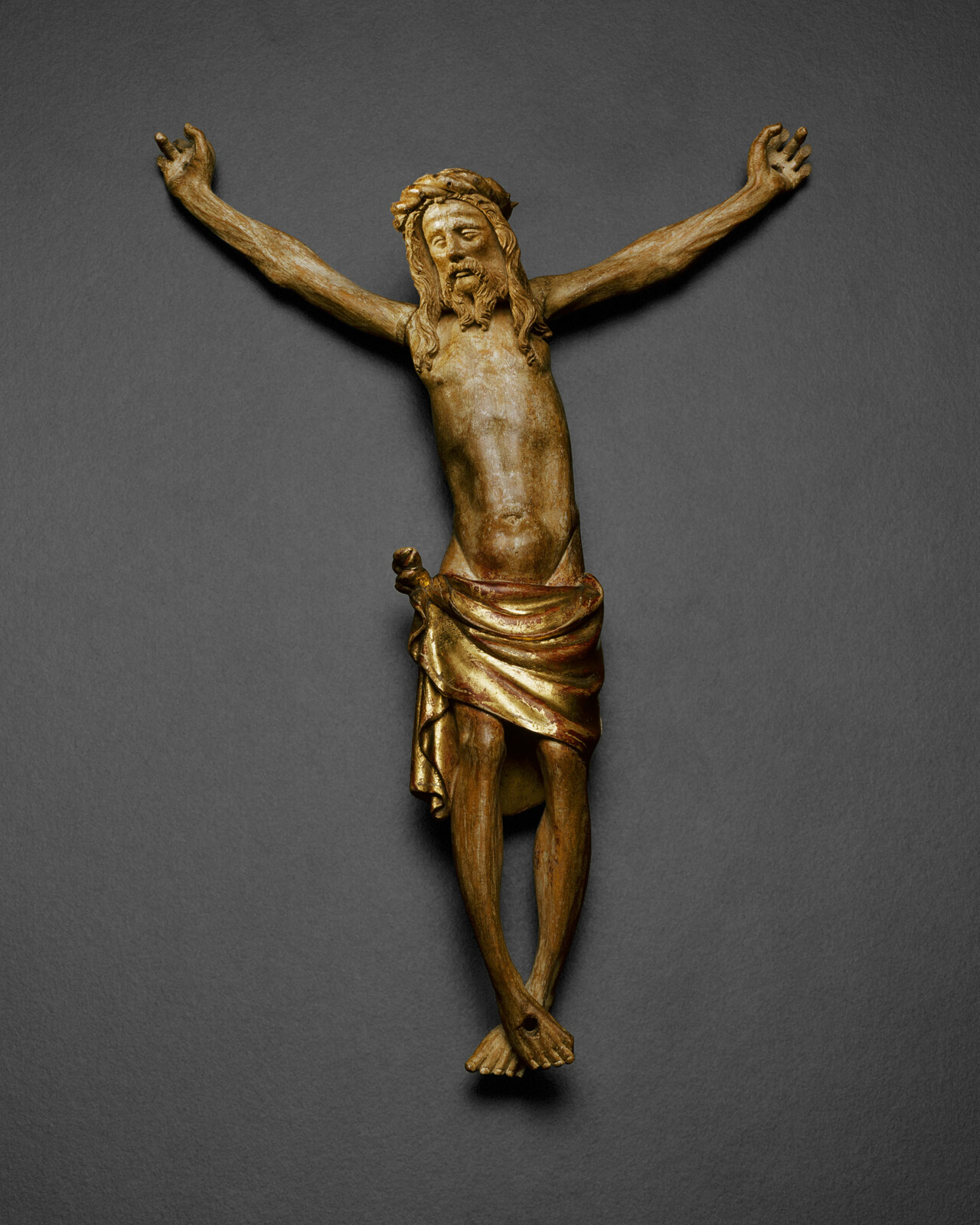 Brown and gold sculpture of crucified Jesus without the cross.