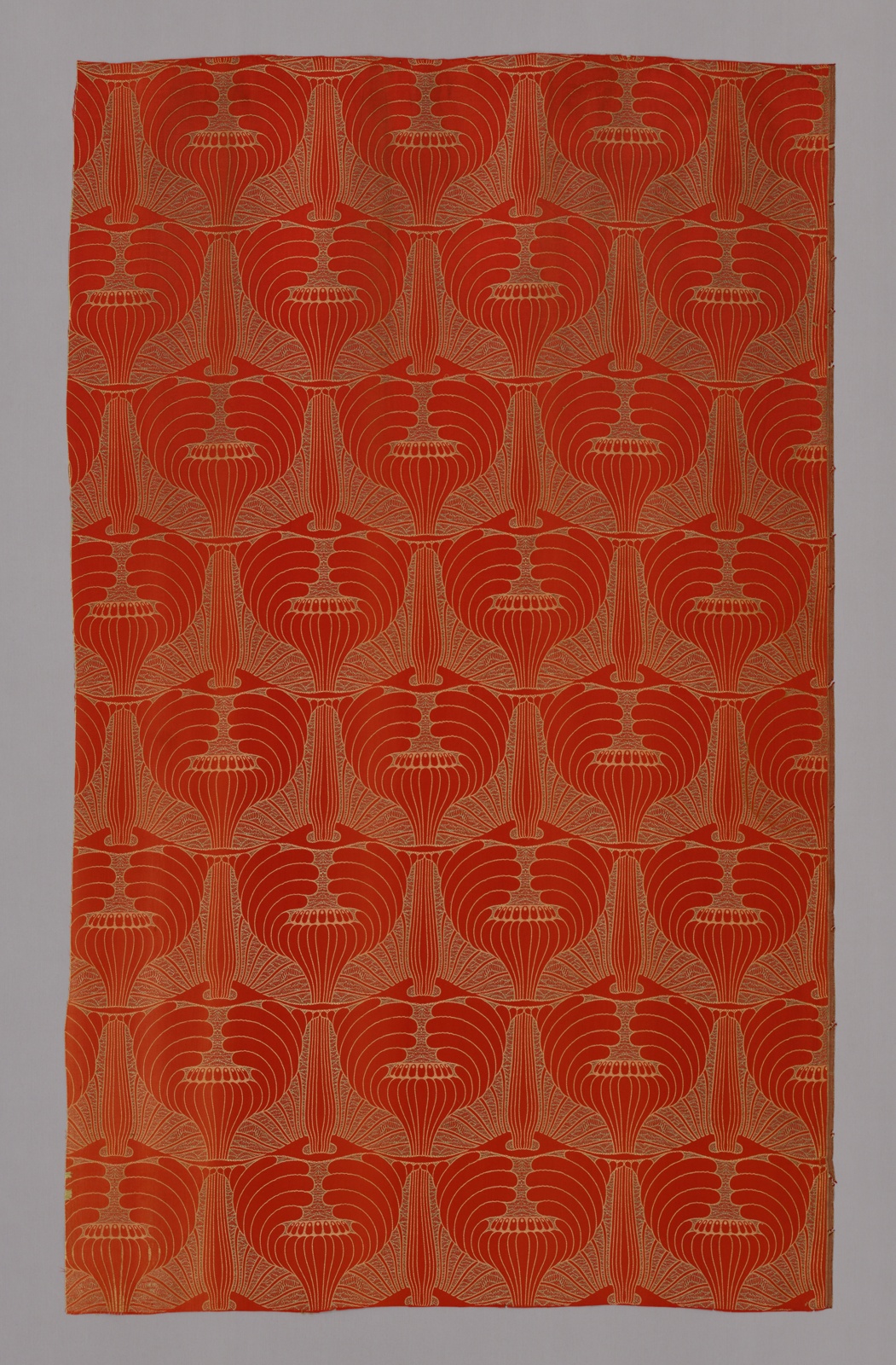 Large panel of red fabric covered in repeating white floral pattern.